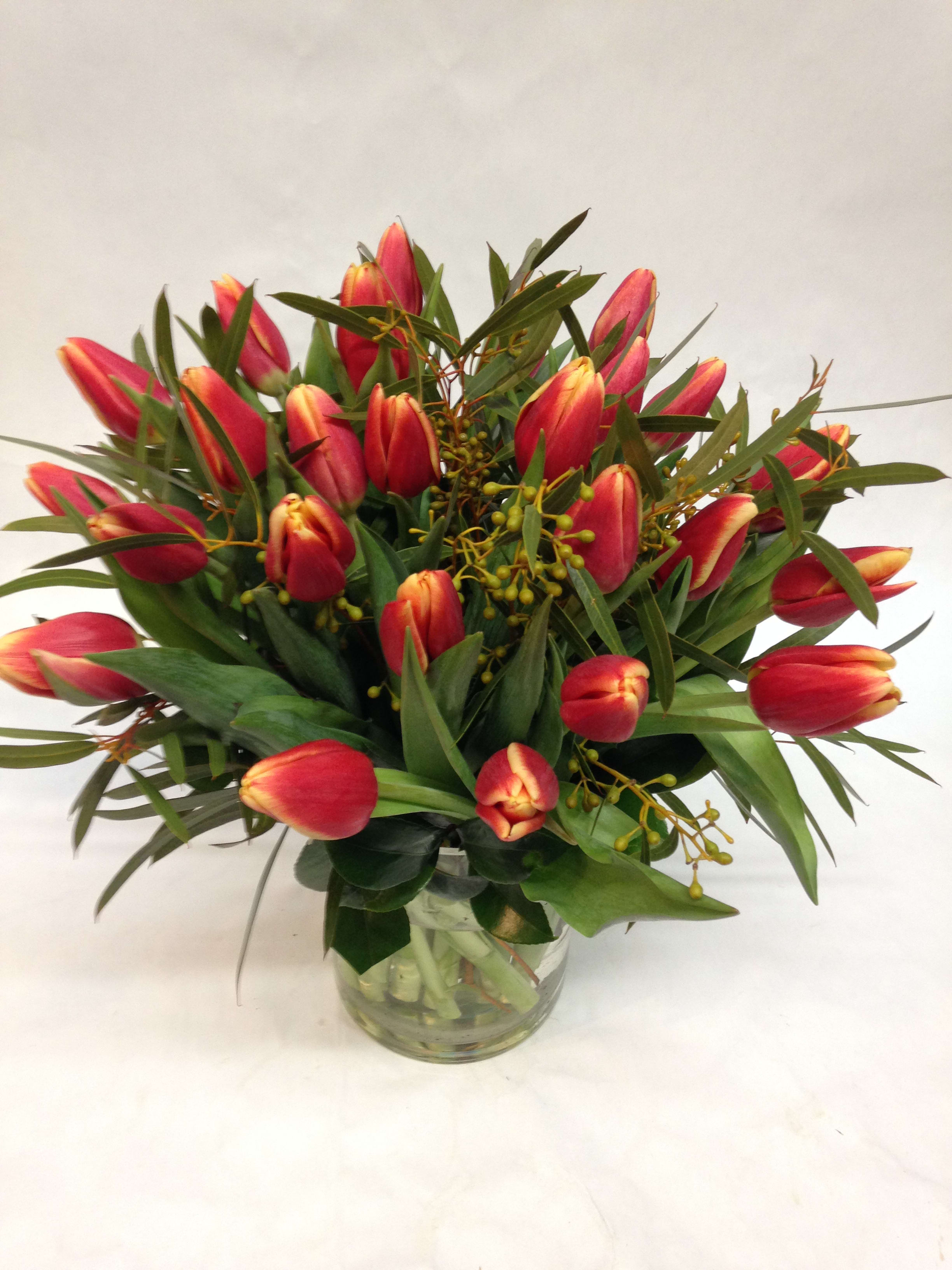 Modern Ombre Tulip Arrangement Modern Ombre Tulip Arrangement - This tulip arrangement can come in a variety of colors: ombre orange, yellow, purple, pink and red. Please specify which color you would like in the special instructions below. (Some flowers may be subject to change depending on the season. We will contact you with available flower substitutions; please contact us with specific questions if you are concerned with flower availability, thanks!) FEATURED ARRANGEMENT $118.00 ( 30 tulips and greenery) (REGULAR PRICE)