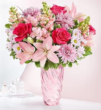 Mother’s embrace - Roses,lilies, carnations, and daisy pomp’s arranged in a pink crystal vase