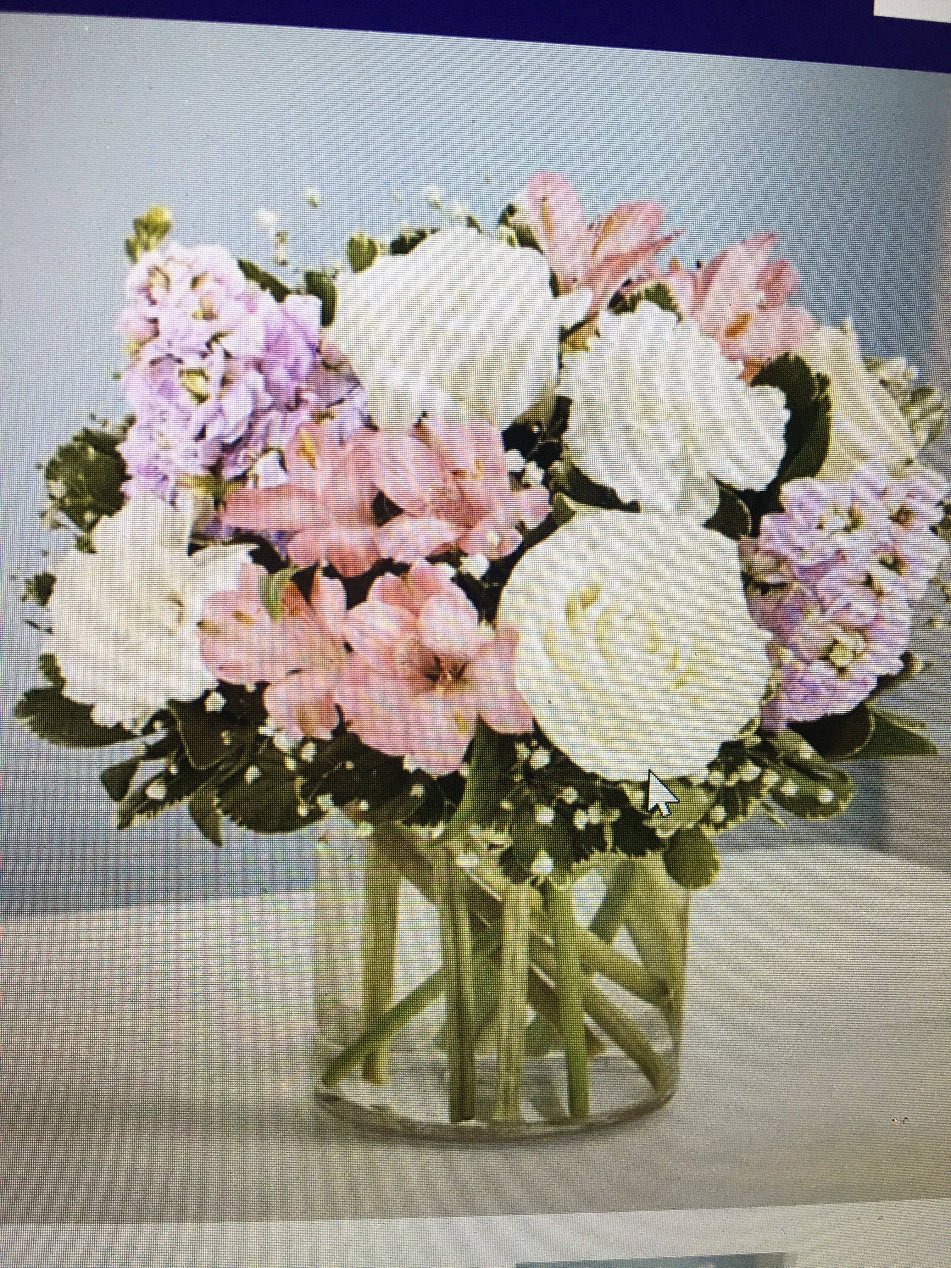 Elegant blush - Lavender pink and white flowers such as stock alstroemeria roses and carnations arranged in a clear vase