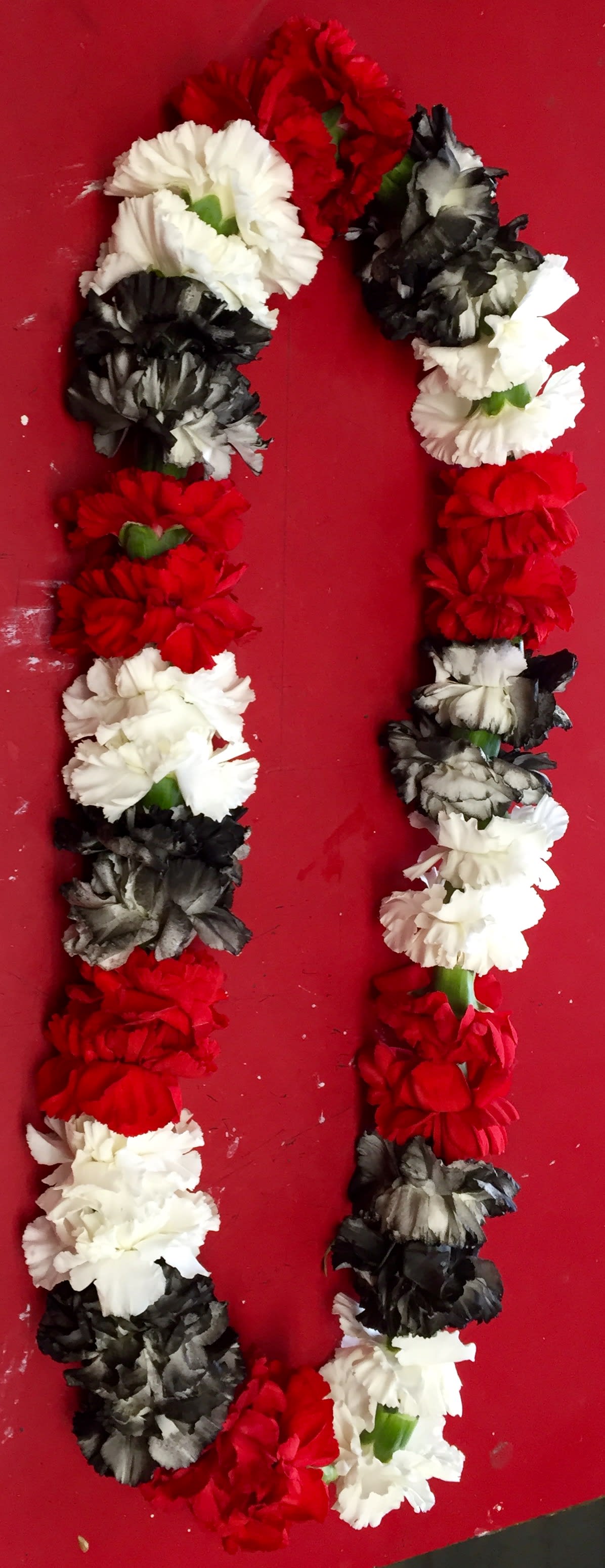 Red, White, &amp; Black Carnation Leis - This elegant Leis features a fresh combination of alternating red, white, and black (dyed) carnations.  Please order two days in advance or call for availability. 