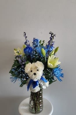 Blue and White vase arrangement with Puppy - Vase arrangement with blue roses white lilies, white stock and blue belladona.