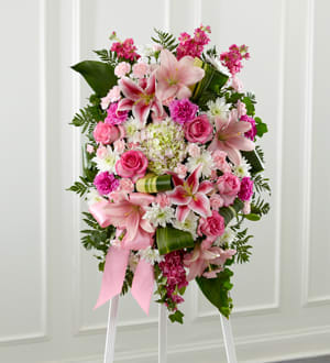 Gently into the Ever After Easle Spray Gently into the Ever After Easle Spray - Bright, fresh, beautiful and just right for an elegant expression of heartfelt sorrow and devastating loss. This classic standing arrangement is constructed by our talented designers of hand-selected pink blossoms ranging from pale pastels to deep blushing pink. It includes roses, carnations, stock, cushion pompons, Asiatic and Stargazer lilies and hydrangea beautifully set among a field of lush contrasting greens like aspidistra and ivy vines. It comes with a wooden easel for flexible display options and makes an impressive memorable tribute at a wake, funeral or graveside service.