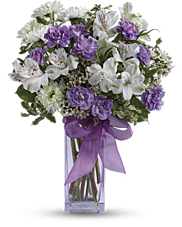 Lavender Laughter Bouquet - Fill her heart with laughter! The ultimate lavender-lover's bouquet, this gleeful gift of white and lavender blooms is delivered in a pretty pale lavender vase she'll cherish forever. Lavender organza ribbon adds that gifting touch. Includes white alstroemeria, miniature lavender carnations, white chrysanthemums and waxflower, accented with fresh pittosporum and lemon leaf. Delivered in a Bunch vase.