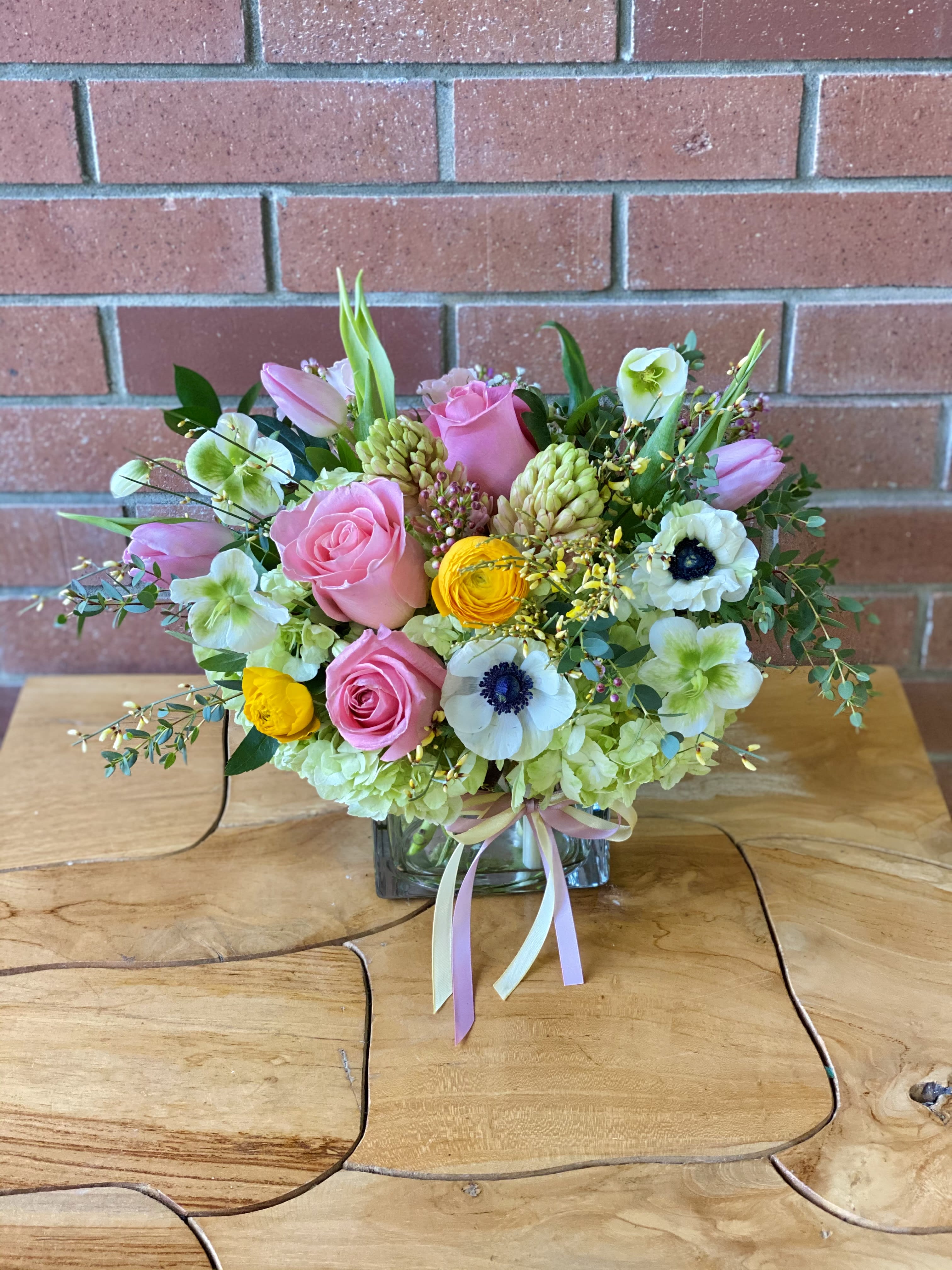 Spring Along Bouquet  - A beautiful array of sweet colorful booms ready to put a sweet smile on anyones face! Expect spring flowers such as anenomes, helleboris, roses, ranunculus, tulips, and other spring filler flowers picked out to make someones day!