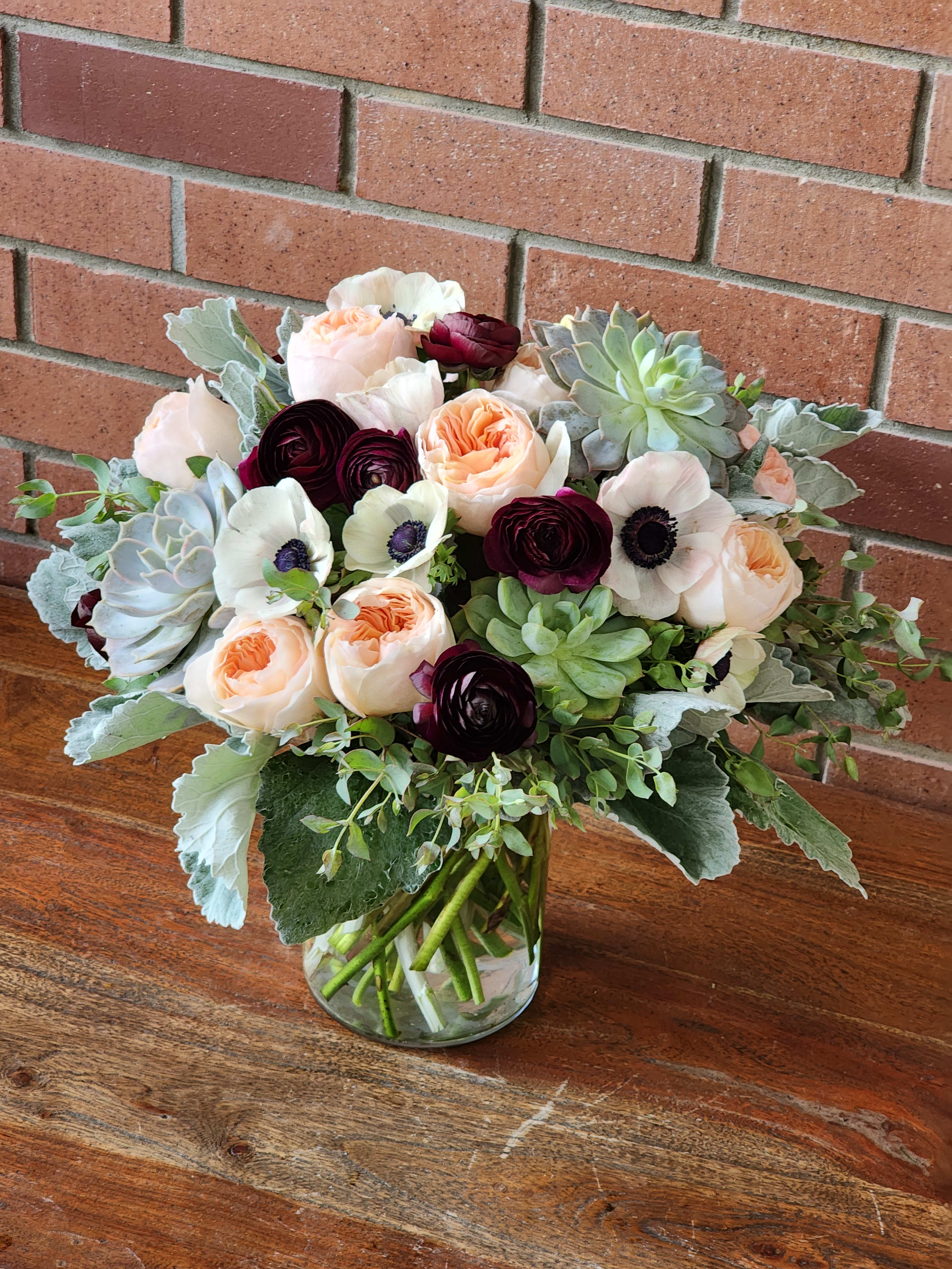 Missing You  - Send these lovely high end blooms to the person you love so very much! A combination of David Austin English garden roses Juliet, anemones, burgundy ranunculus, succulents, dusty miller and Eucalyptus. 
