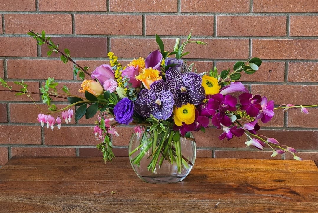 Tropical Oasis Bouquet - As you walk in Venice, you see lots of colorful blooms - some tropical others not. This bouquet is inspired by the beautiful colors surrounding us in Venice. Add color to your loved one's day! Orchids, ranunculus, lisianthus, mini calla lilies, greenery and pink fillers. 