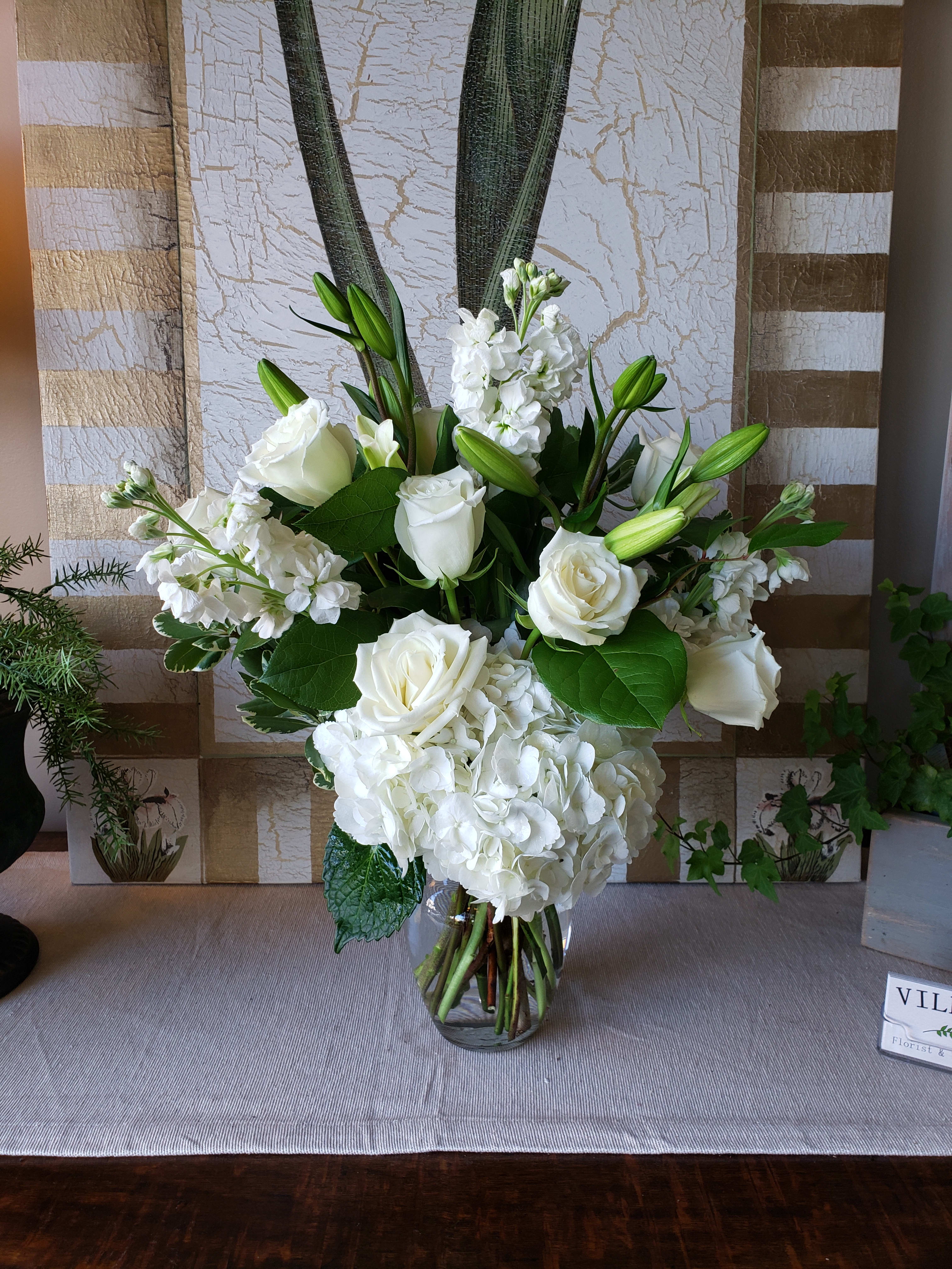 Heavenly  - A classy bouquet with a variety of white and cream blossoms. Beautiful white hydrangea, spray roses and stock, white roses and eucalyptus. For Custom Orders and Upgrade Options, please contact our shop directly at 732-341-3723.  