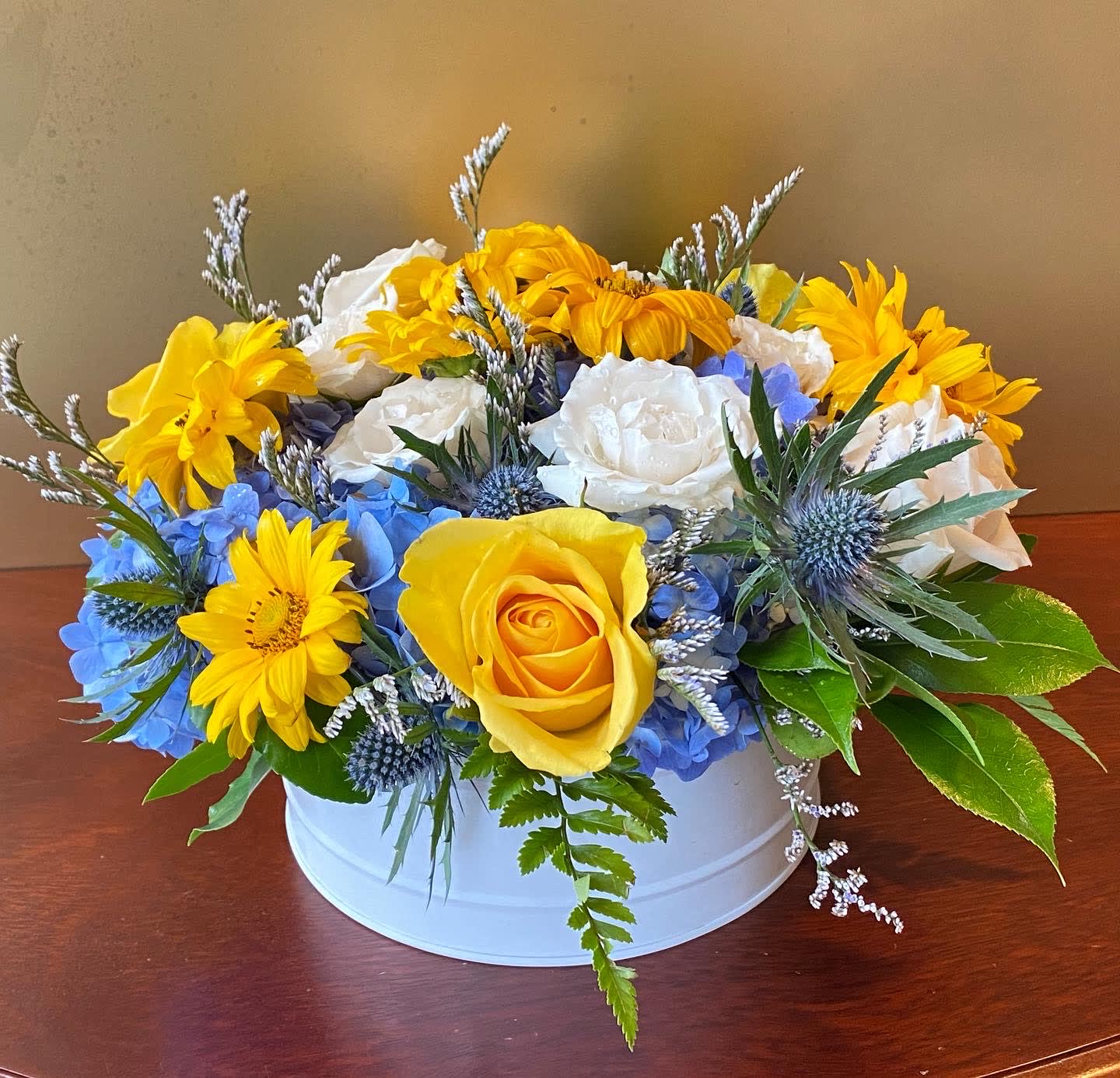 Big Bright Blue Skies Big Bright Blue Skies - The Bright Blue Skies Bouquet is arranged by a local florist close to the recipient's home. This arrangement includes a variety of flowers and colors - yellow roses, white roses, blue hydrangeas and yellow daisies , all in a white container. Blue bouquets have become universal in their message, whether it be for a birthday or for a get well, they are a perfect gift for any occasion.