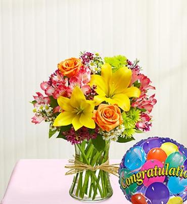 Fields of Europe Congratulations Fields of Europe Congratulations - Congratulate them with elegance and style -- send our hand-gathered bouquet of roses, lilies, alstroemeria, poms and more, arranged by our florists inside a stylish clear glass vase tied with raffia as a nod to rustic European style and paired with a festive balloon. (Vase/Basket style may vary) Item # 90980