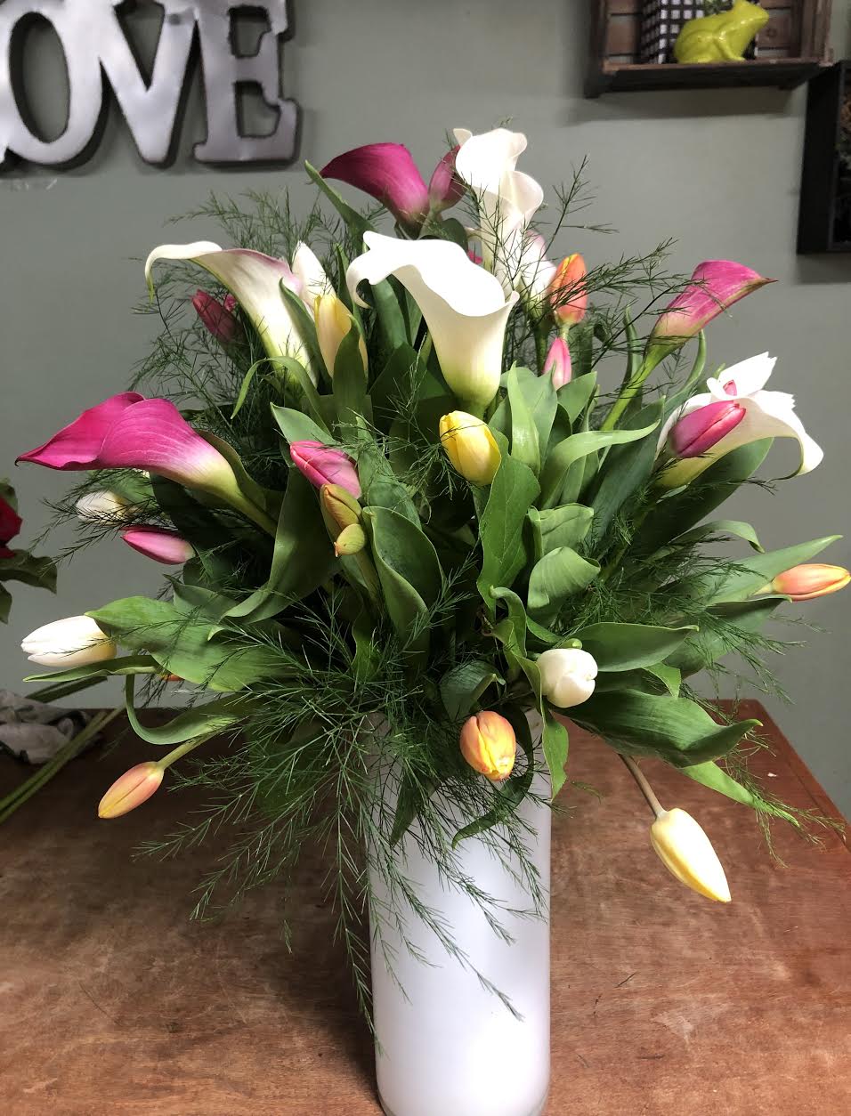 Stylish Spring Stylish Spring - MIX TULLIPS, CALLALILYS WITH GREENERY IN A TALL GLASS VASE.