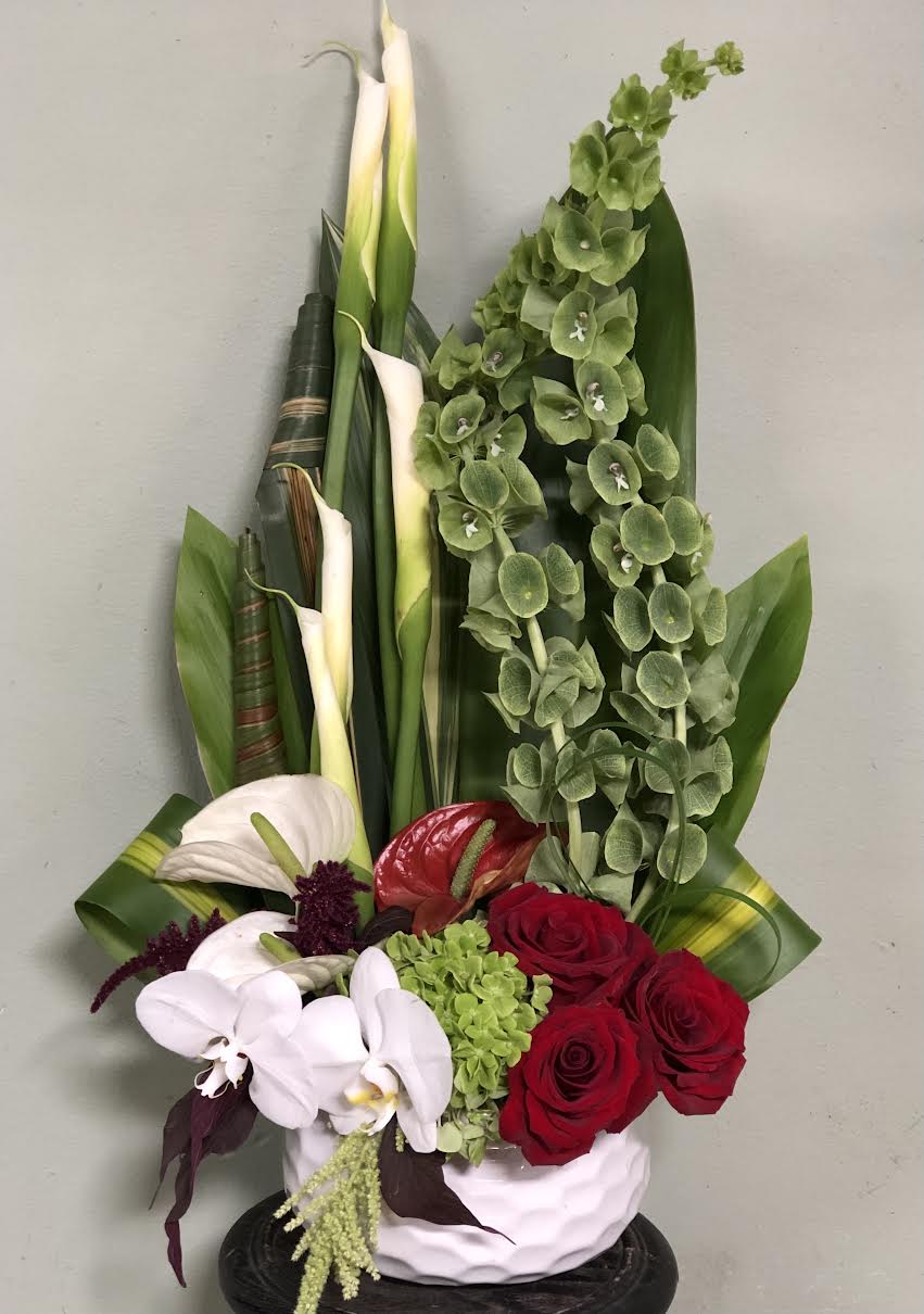 Glamour Bells - Bells of Ireland,Calla Lilies, Roses, Anthurium flower, etc all arranged in White vase.