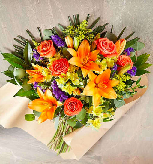Wild Beauty Cheerful Bouquet - JUST GATHERED! When Cheerful shows up, all eyes light up. Showcasing sunny orange and yellow blooms, and pops of purple for added warmth, this boisterous bouquet has a beauty that speaks to everyone.