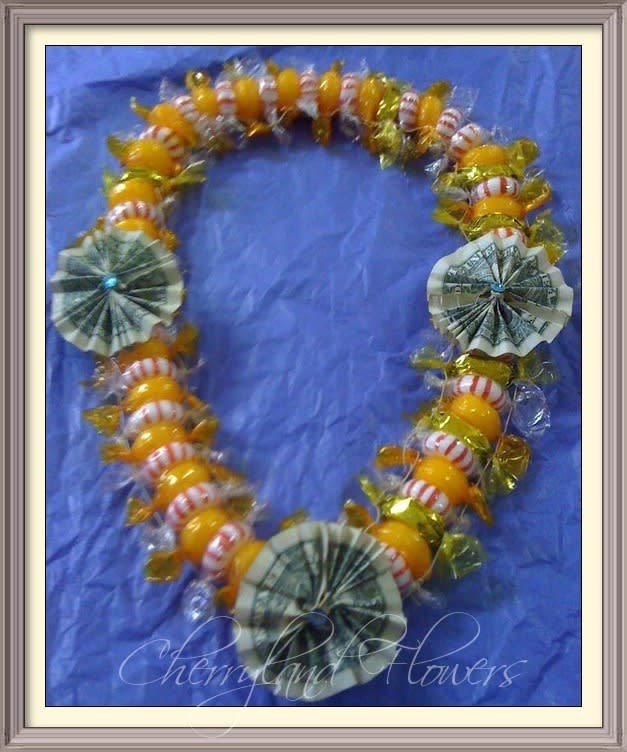 Candy Lei$ - This cheerful lei features alternating butterscotch, peppermint, and caramel candies adorned with three $1 bills. 