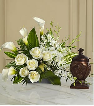 The FTD® At Peace™ Arrangement The FTD® At Peace™ Arrangement - This extraordinary mixed flower bouquet is an excellent choice for creating a beautiful, serene and reverential setting for an urn containing the cremated remains of the deceased. The asymmetrical arrangement is hand-arranged by a local FTD artisan florist and includes Dendrobium orchids, roses, calla lilies, and lush, complementary greenery in a low silvery plastic rectangular container. Beautiful on its own or to enhance a display of a meaningful memento, photograph or candle. Your purchase includes a complimentary personalized gift message.