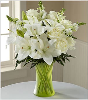 The FTD® Eternal Friendship™ Bouquet - An exuberance of bright and beautiful white blossoms provides an exquisite way to deliver your expressions of sympathy and comfort. This life affirming tribute combines white roses, snapdragons and Asiatic lilies accented by lush greens arranged in a matte, green glass gathering vase. An excellent choice for a wake, funeral service or for sending your condolences to the home of grieving family or friends.  Your purchase includes a complimentary personalized gift message.