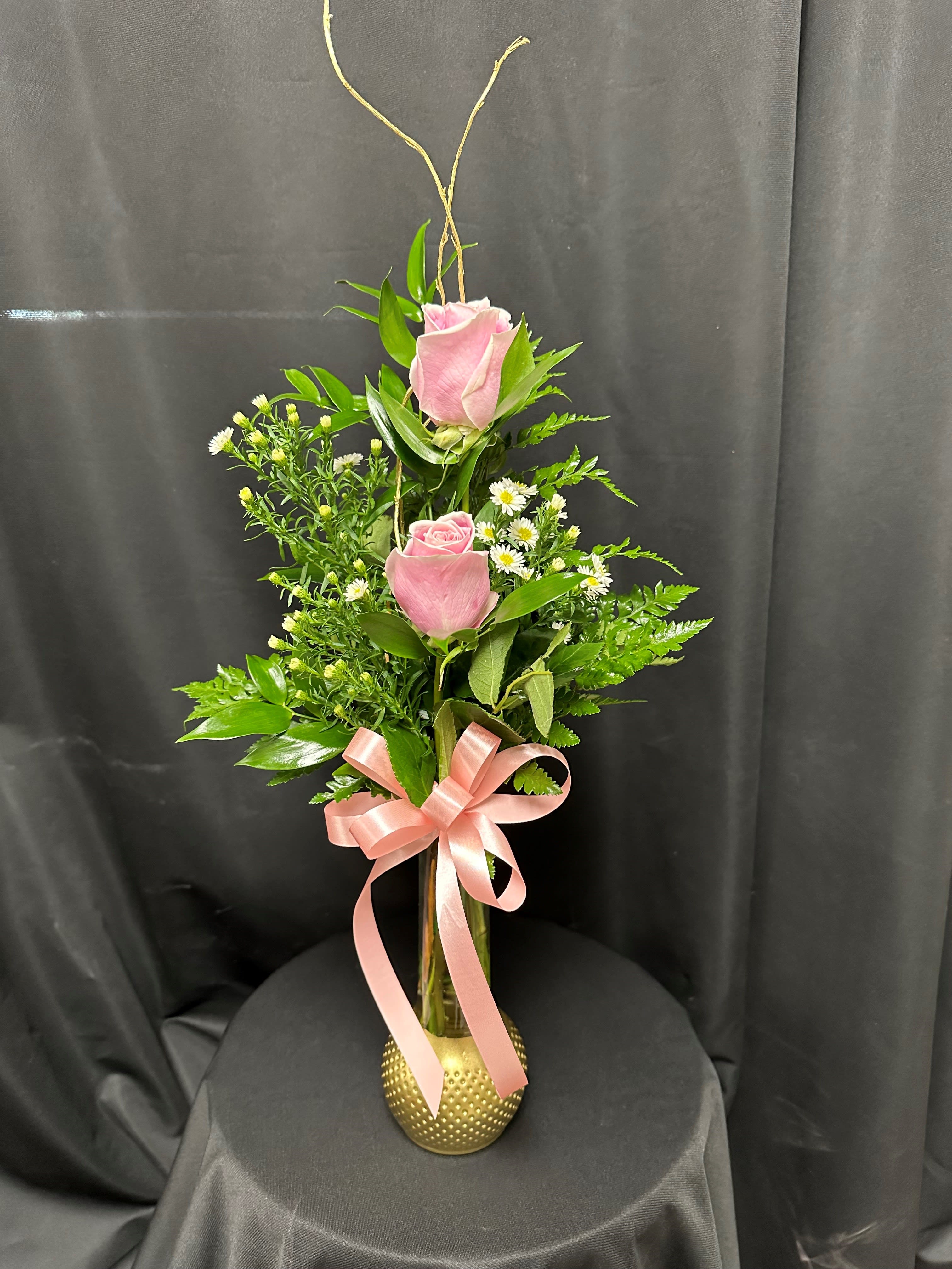 Dreaming of Genie - Bring some whimsy into her life with beautiful pink roses surrounded by greens, white monte casino, and a pink bow in a gold bottom vase.