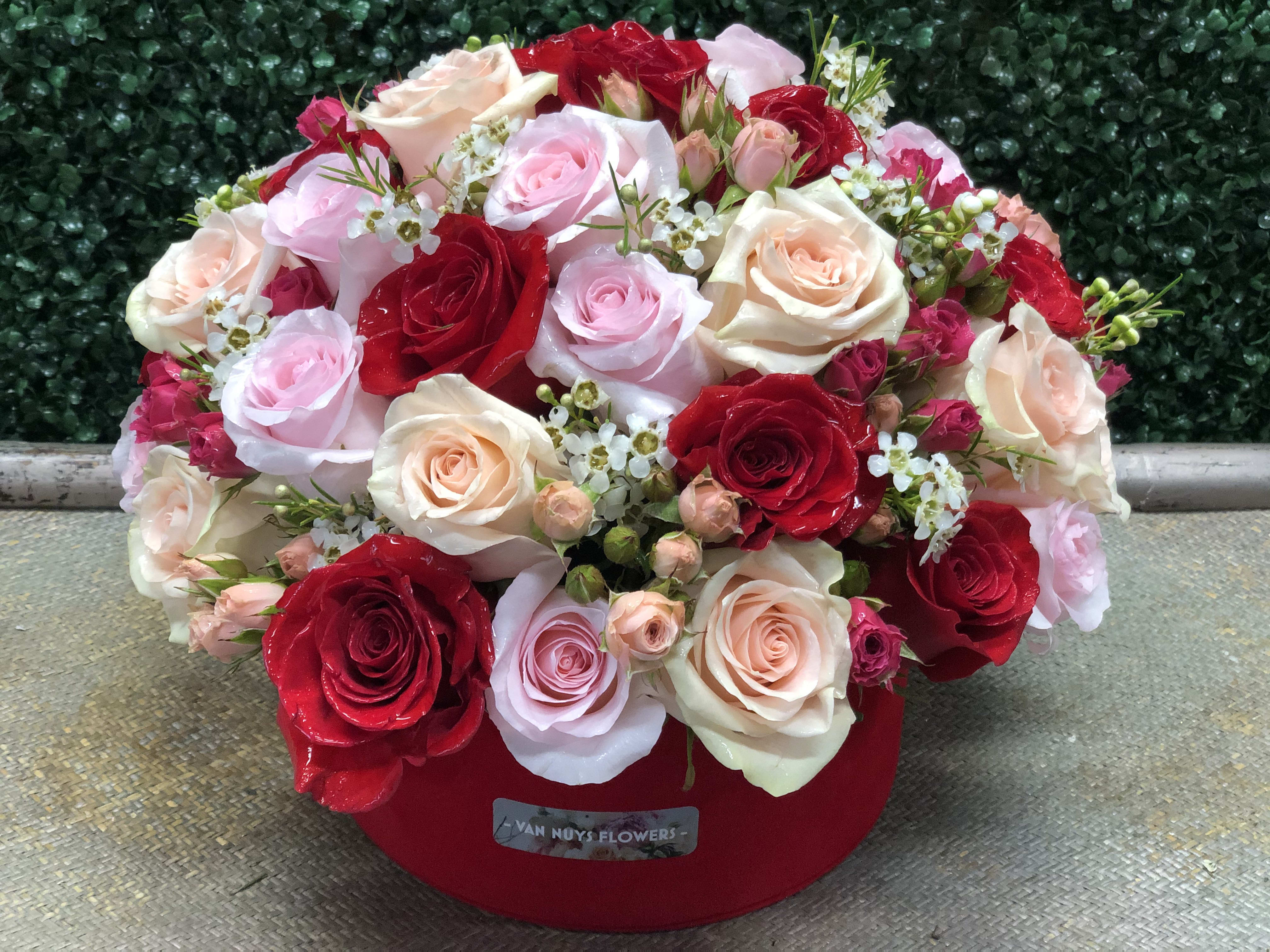BLOOMING BEAUTY - A MIXTURE OF RED,PINK AND PEACH ROSES MAKE FOR A STUNNING FLORAL. ROSES, SPRAY ROSE,WAX FLOWER