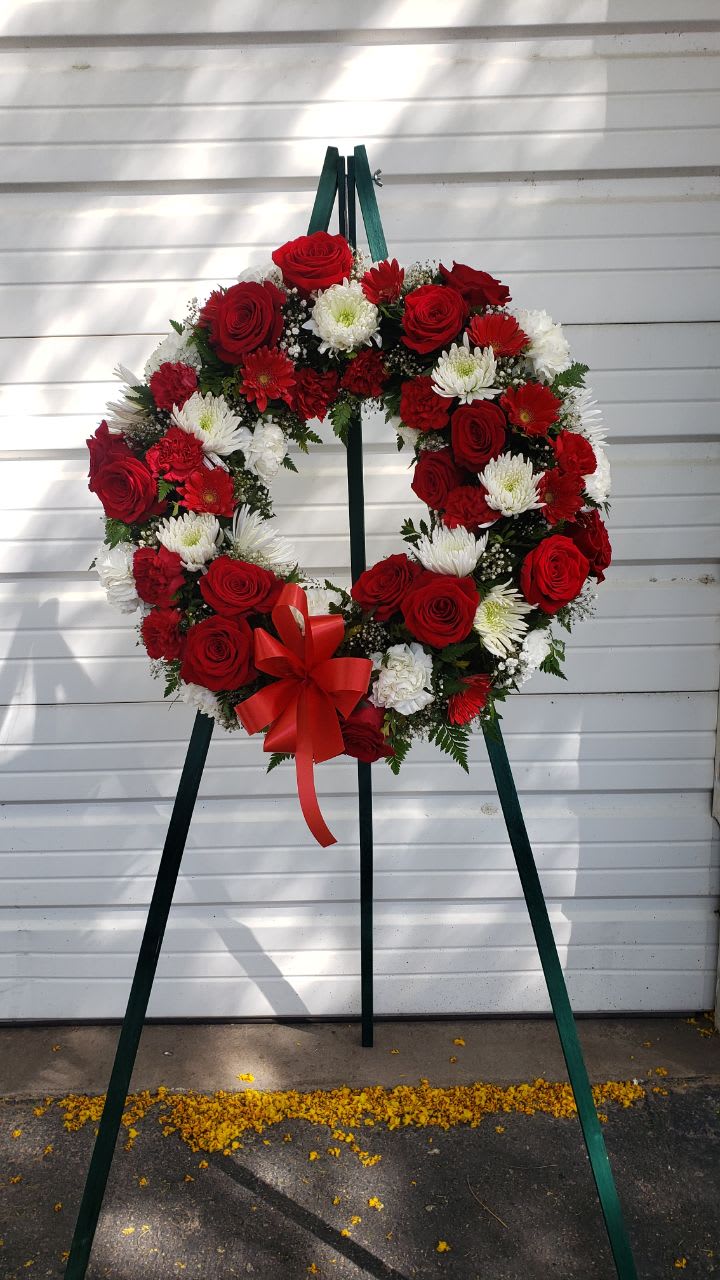 Red and White wreath Red and White wreath - 15 red roses, 11 white spider mums ,8 white carnation . 8 red carnation, 4 red gerbera daisy, 2 stem white baby breath and a medium red bows. in a wire easel wreath is 18 inch.