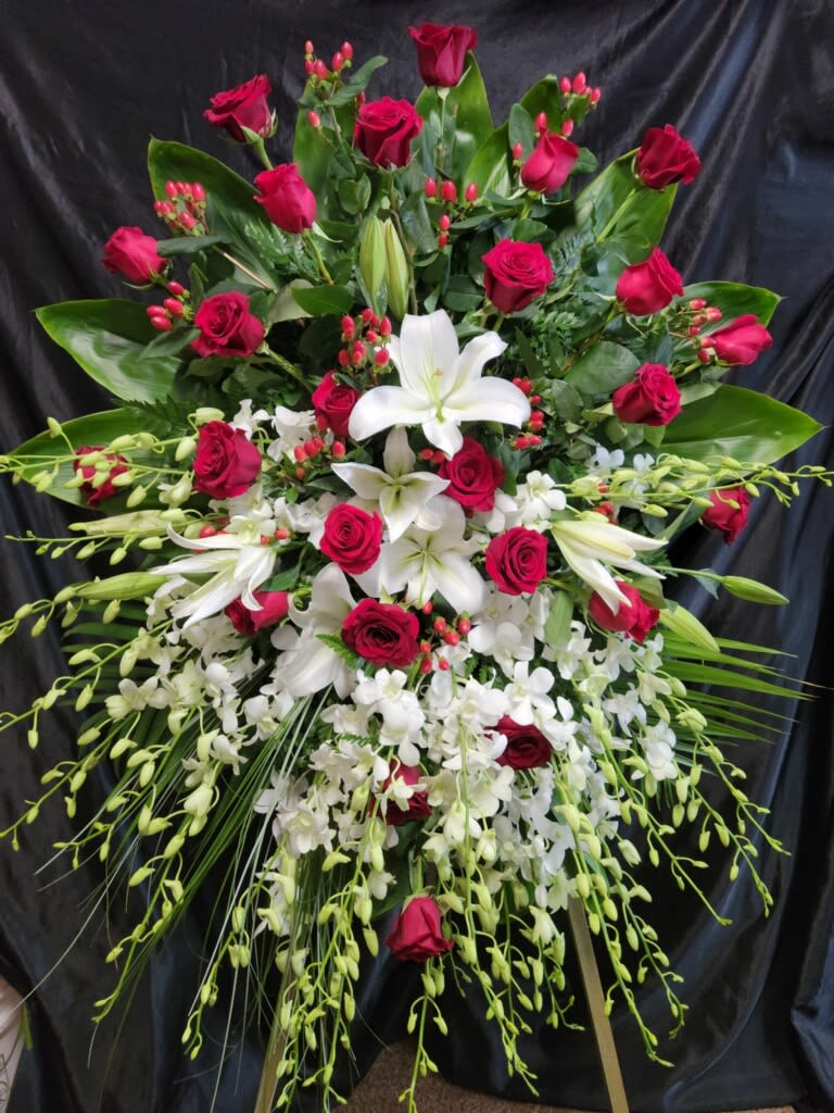 Premium Freestyle Standing Spray. PR # 1 A - 24 Red roses  with White orchid sprays  Large White Lilies —we reserve the possibility to sub lilies with White Mums    ____SMALLER Version   Priced as 475.00