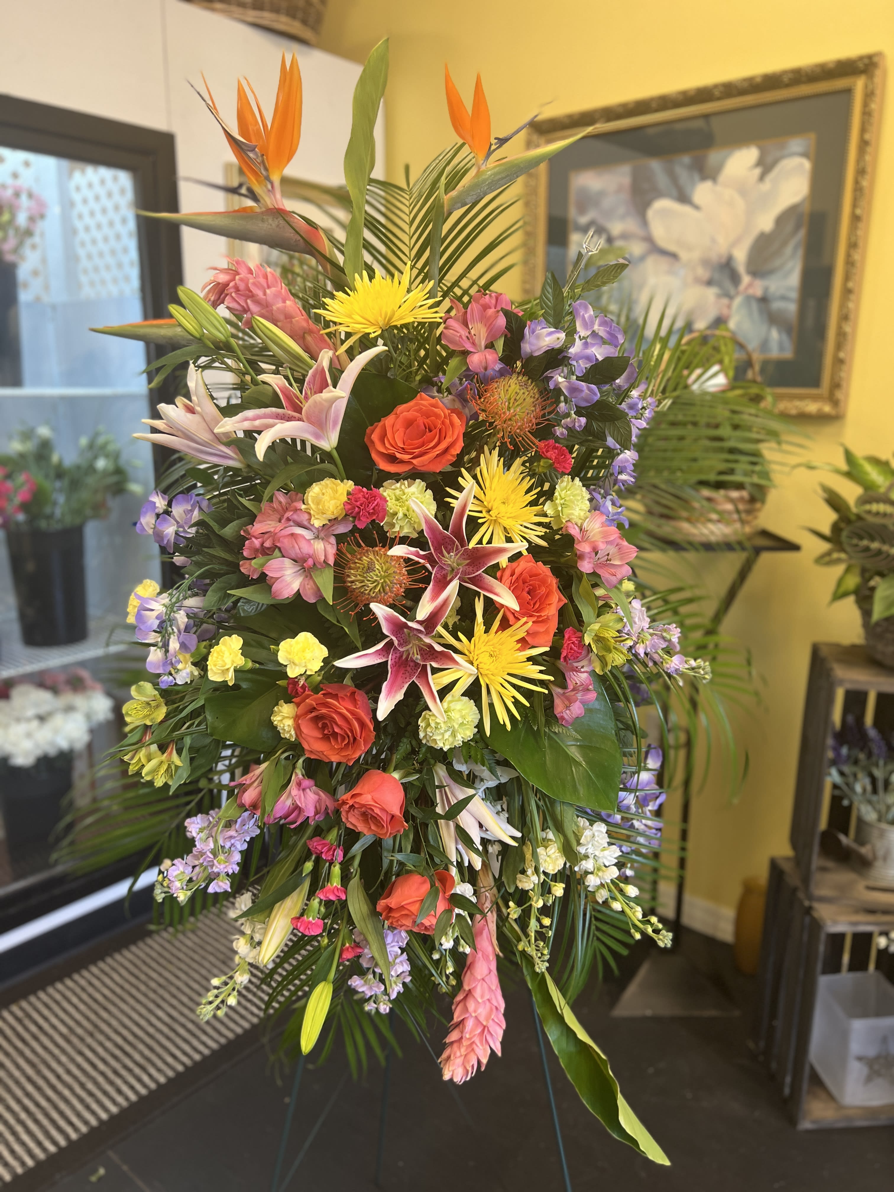Tropical Tribute - Their passion and joy for life will always be remembered. Our tropical standing spray arrangement was designed to capture that colorful spirit. Elegantly crafted for a lush, full presentation, this vibrant mix of blooms creates a memorable tribute to someone who was truly one-of-a-kind.