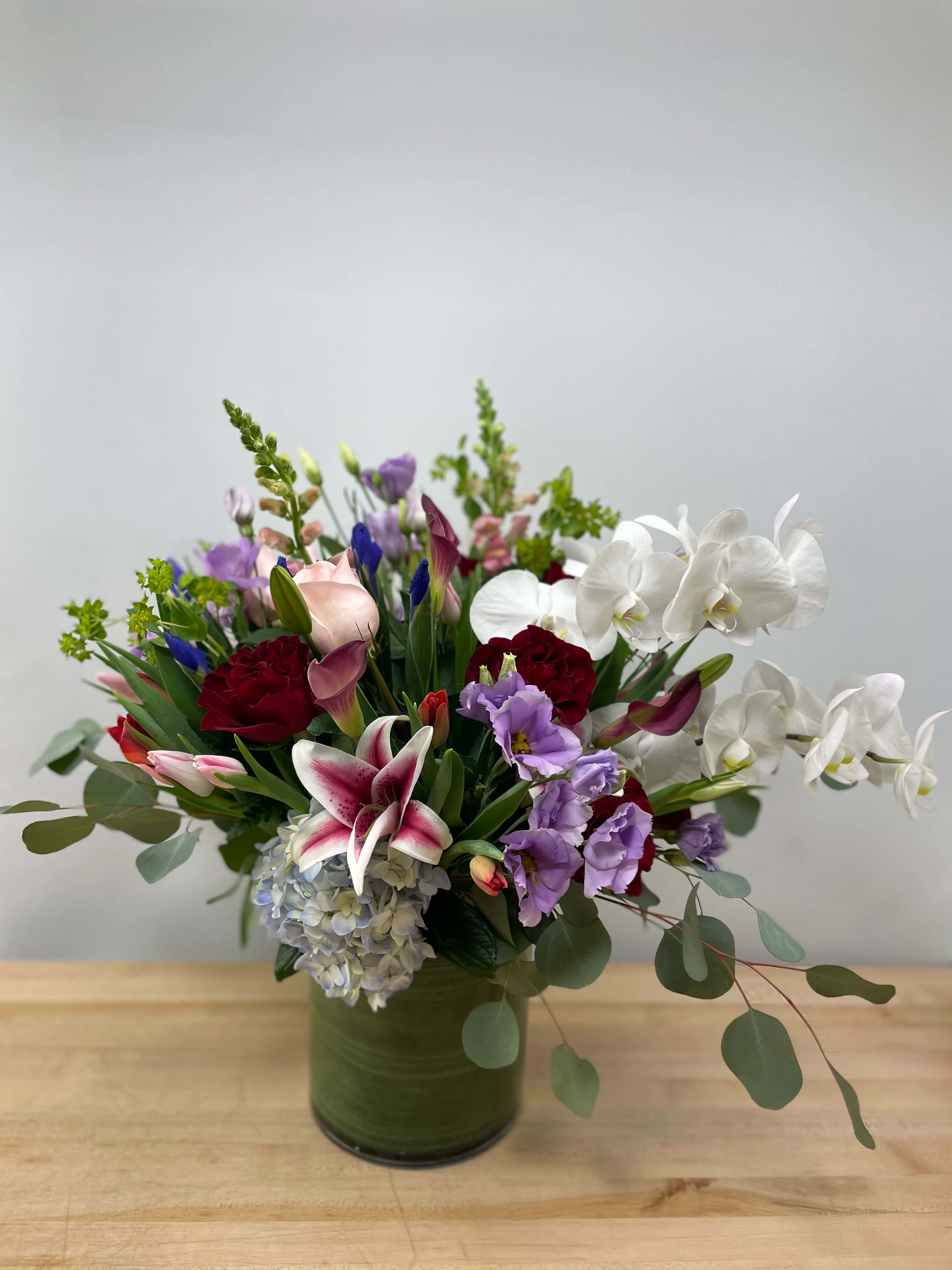 Maria Maria - An arrangement to show affection to loved ones in a grand gesture. With a variety of lavender, pink, white, red, and blue shades of flowers to compliment any special occasion. This arrangement is in a 6x6 cylinder vase.