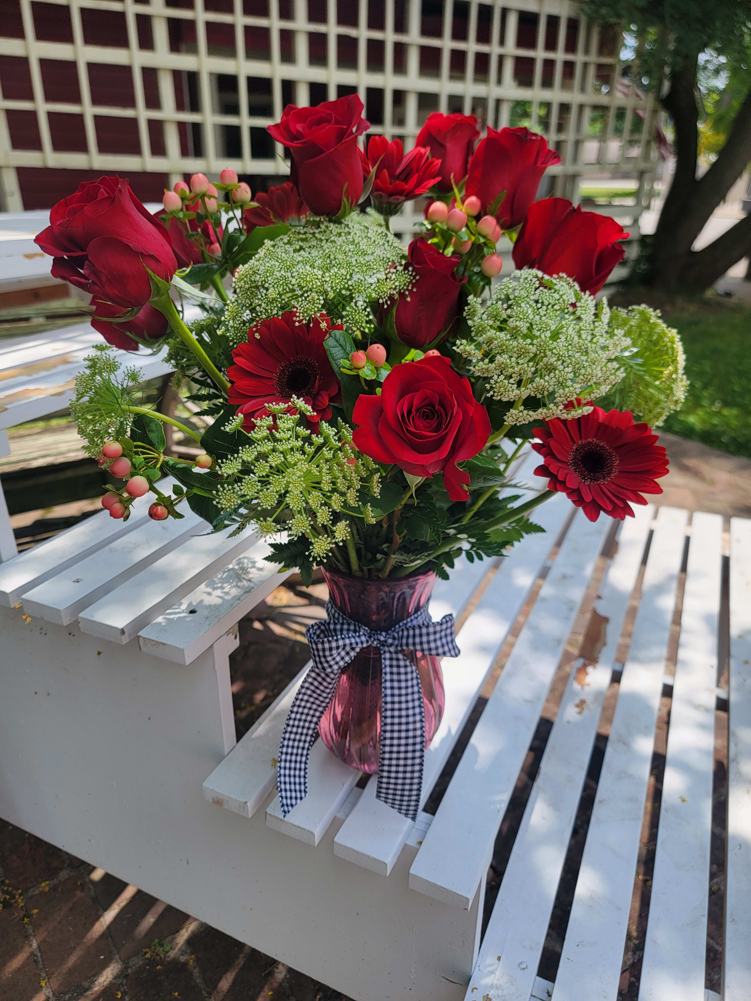 Ruby Slipper - An absolute stunning arrangement custom created for your special recipient. Ruby Slipper includes red roses, red gerbers, wax flower filler and queen ann's lace. 