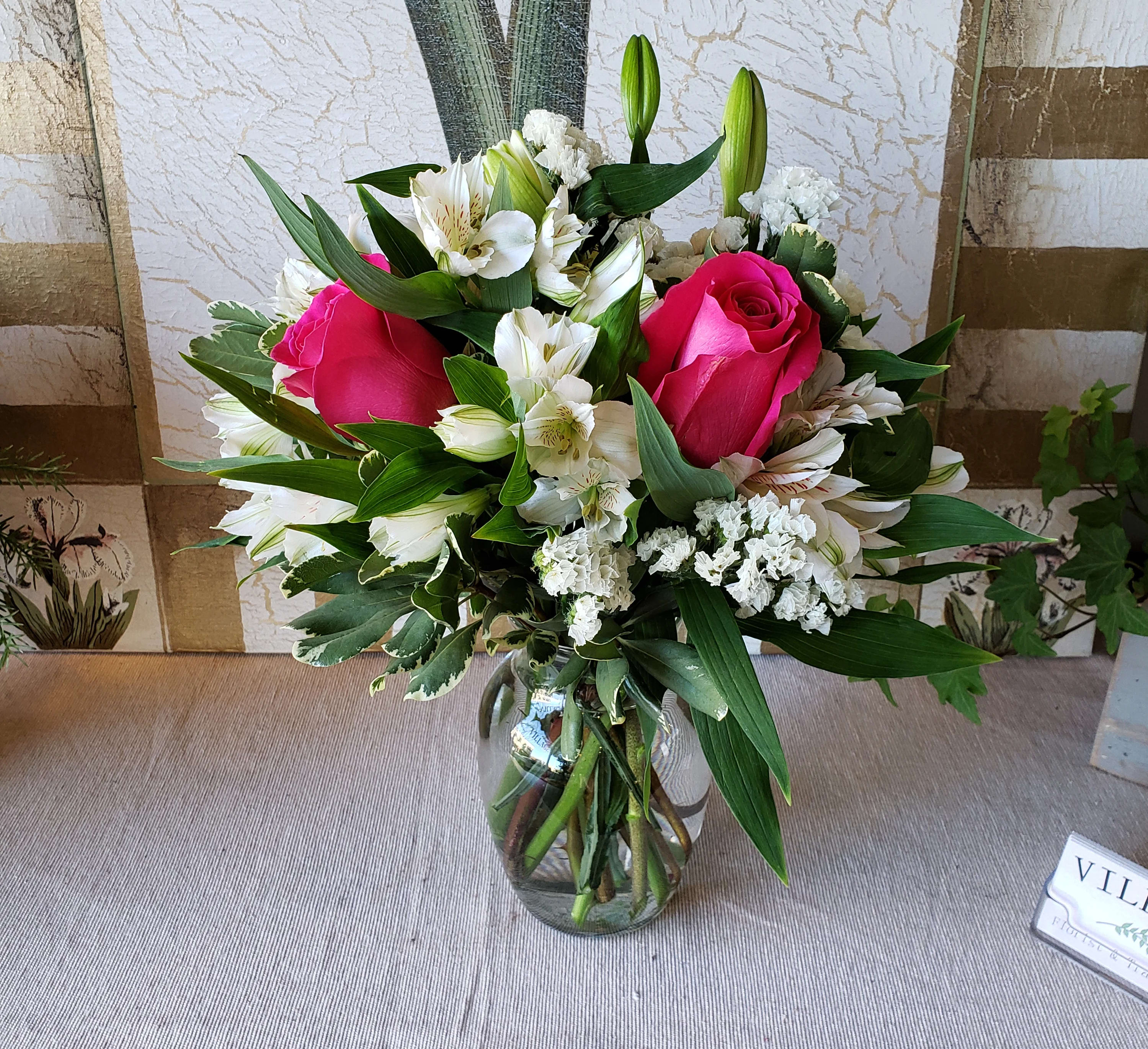 Classy and Sassy - Classy and Sassy is an elegant mix of white lilies, white Alstroemeria and white Statice with a Sassy pop of Pink Floyd Roses. Tastefully arranged in a clear glass vase. 