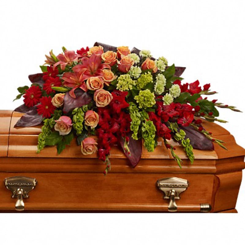 A Fond Farewell Casket Spray [T271-3A] - An overflowing of love and respect is joyfully expressed in this truly magnificent casket spray of orange roses and lilies and other brilliant blooms.  The magnificent arrangement includes green miniature hydrangea, orange roses, dark orange asiatic lilies, red gerberas, red gladioli, green carnations and bells of Ireland, accented with assorted greenery.  Approximately 44&quot; W x 25&quot; H  Orientation: N/A  As Shown : T271-3A