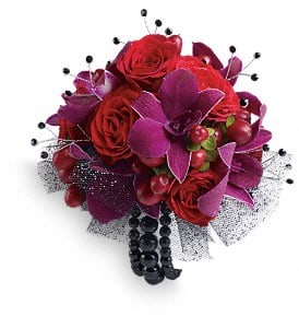 Celebrity Style Corsage Celebrity Style Corsage - Flirt with fame in this feminine arrangement of exotic orchids, roses and hypericum. Purple dendrobium orchids, red spray roses and red hypericum with black rhinestone accents. Approximately 5 1/2" W x 5 1/2" H Orientation: N/A