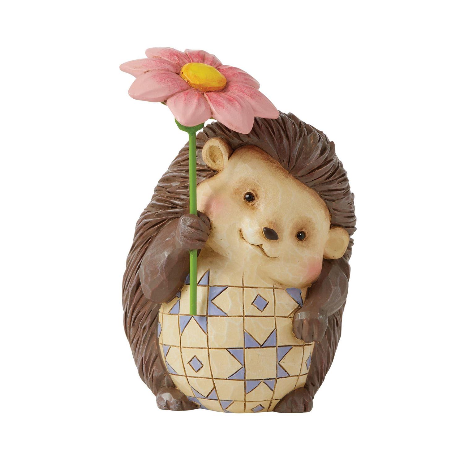 Jim Shore - Mini Hedgehog - Description  These charming friends of the forest bring a small dose of delight into your home with sweet dispositions and delicate craftsmanship. With gentle gazes and soft smiles Jim Shore creates a miniature to cherish. This happy hedgehog holds a flower.  Figurine 4.25in H Jim Shore Heartwood Creek Mini Figurine Collection Beautifully hand-painted and crafted from high-quality stone resin with intricate styling and attention to detail Jim Shore's unmistakable style evokes a sense of nostalgia with traditional themes, quilt patterns and design motifs inspired by American and European Packaged in individual box with photo on front 4.25 in H