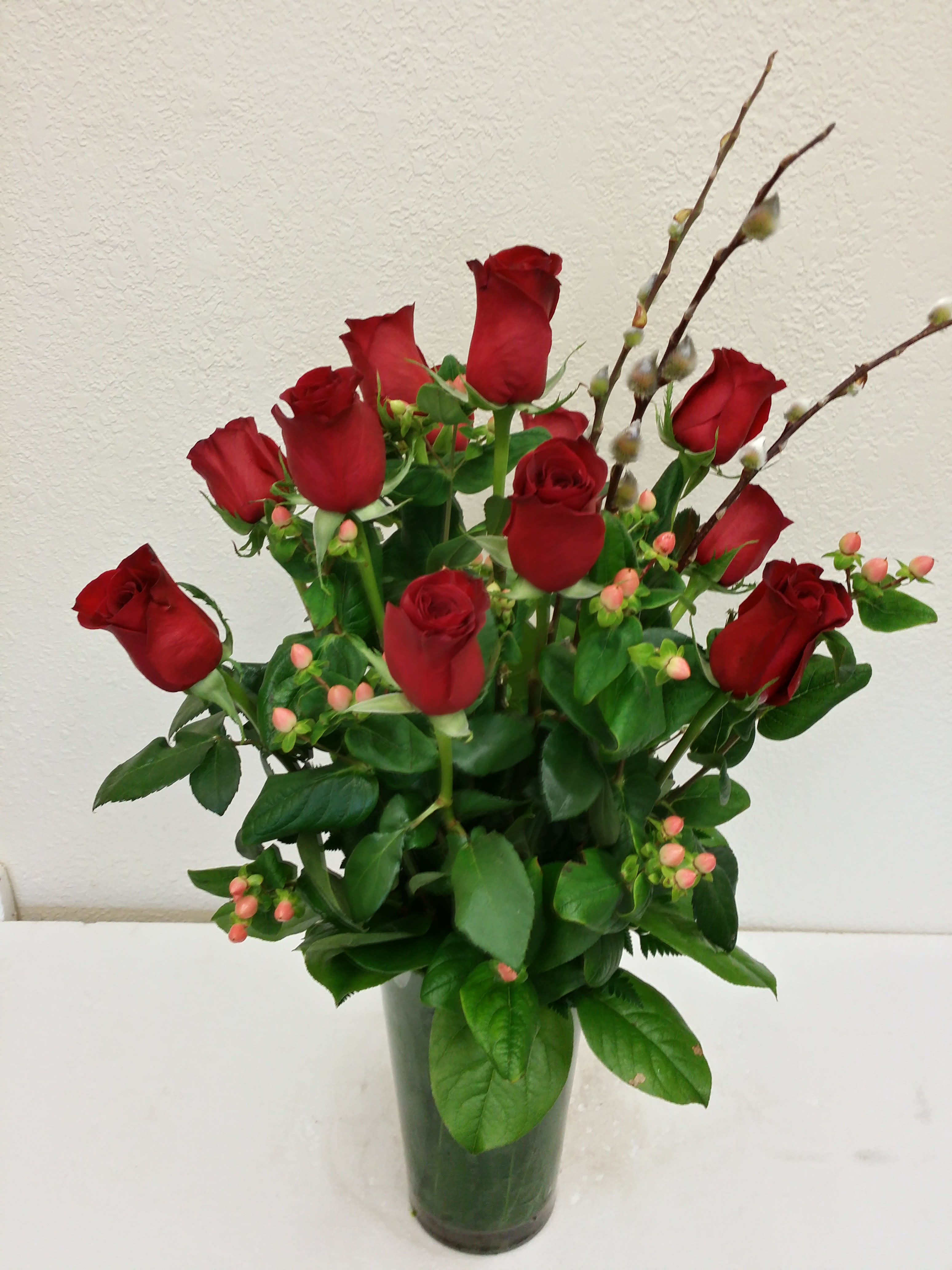 Traditional dozen long stem red roses Traditional dozen long stem red roses - In a leaf lined vase with spring branches, baby's Breath can be added upon request at no additional charge, but it will only added if requested under special instructions, otherwise we do NOT add it, we use red hypericum berry instead
