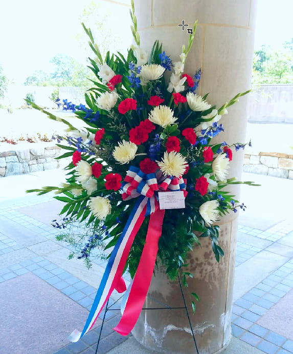 Patriotic Spirit Spray [TF215-3] - This spirited standing spray will imbue everyone in attendance with a sense of patriotism.  One standing spray on an easel arrives with red carnations, blue delphinium and white gladioli and a patriotic red, white and blue ribbon.  Approximately 32&quot; W x 48&quot; H  Orientation: One-Sided      As Shown : TF215-3 