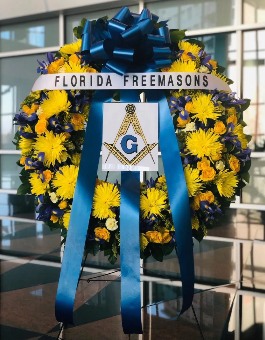 36&quot; FREEMASON WREATH WITH BANNER AND PLACARD - FREEMASON WREATH  BY TWIN TOWERS FLORIST WITH HORIZONTAL BANNER AND SQUARE AND COMPASS MASONIC LOGO ENCASED IN A CUSTOM ACRYLIC PLACARD.  AS SHOWN:  36&quot; DIAMETER WREATH