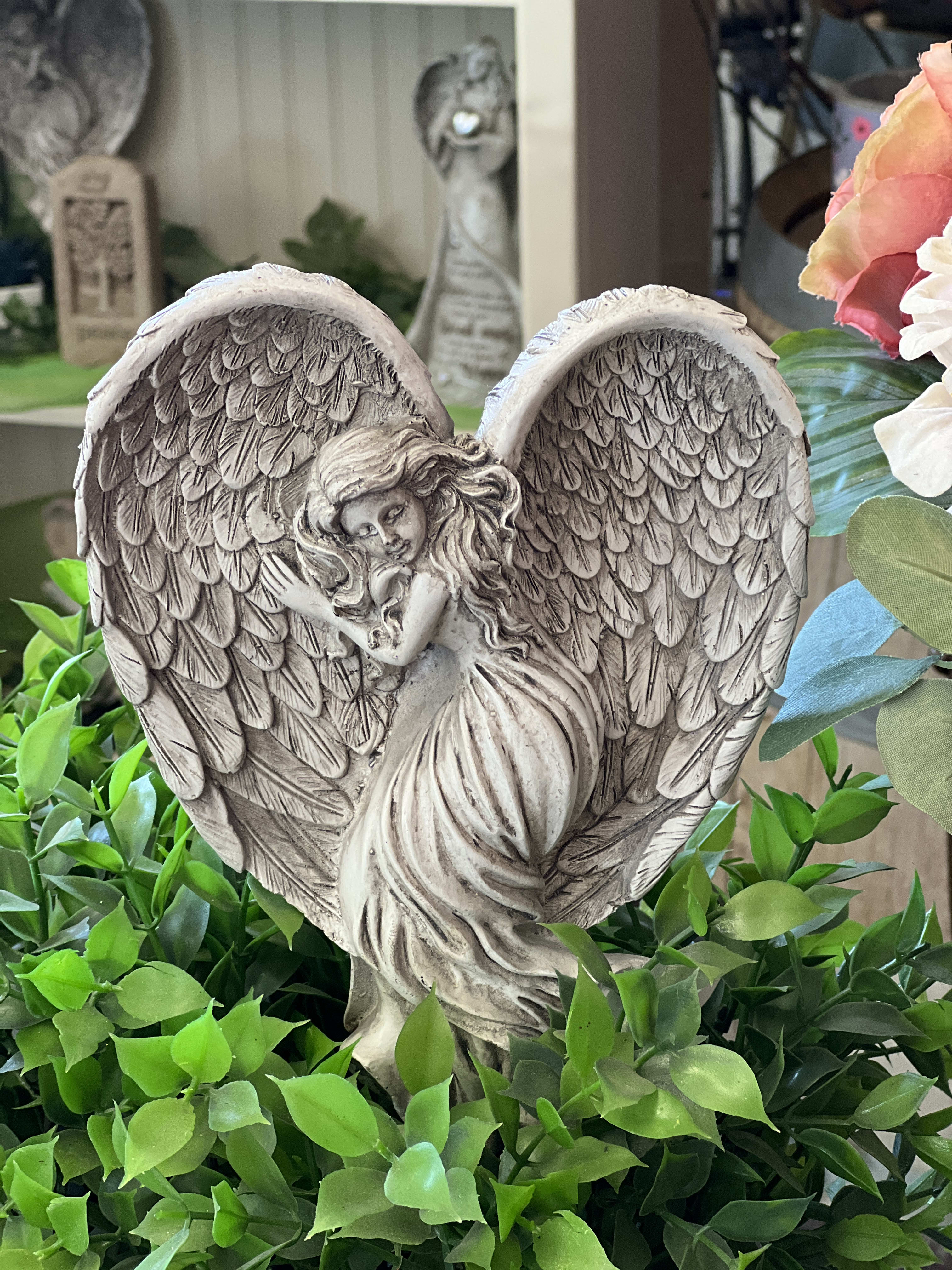 Angel Insert - Heart Wings Angel Insert - Heart Wings - A resin angel that is designed to be inserted into a plant basket, garden or floral arrangement, her wings fold in such a way that a heart shape is created. If you choose this add-on, we will insert it artfully into your flowers/plants. Approx: 6.5" wide and 8.5" tall