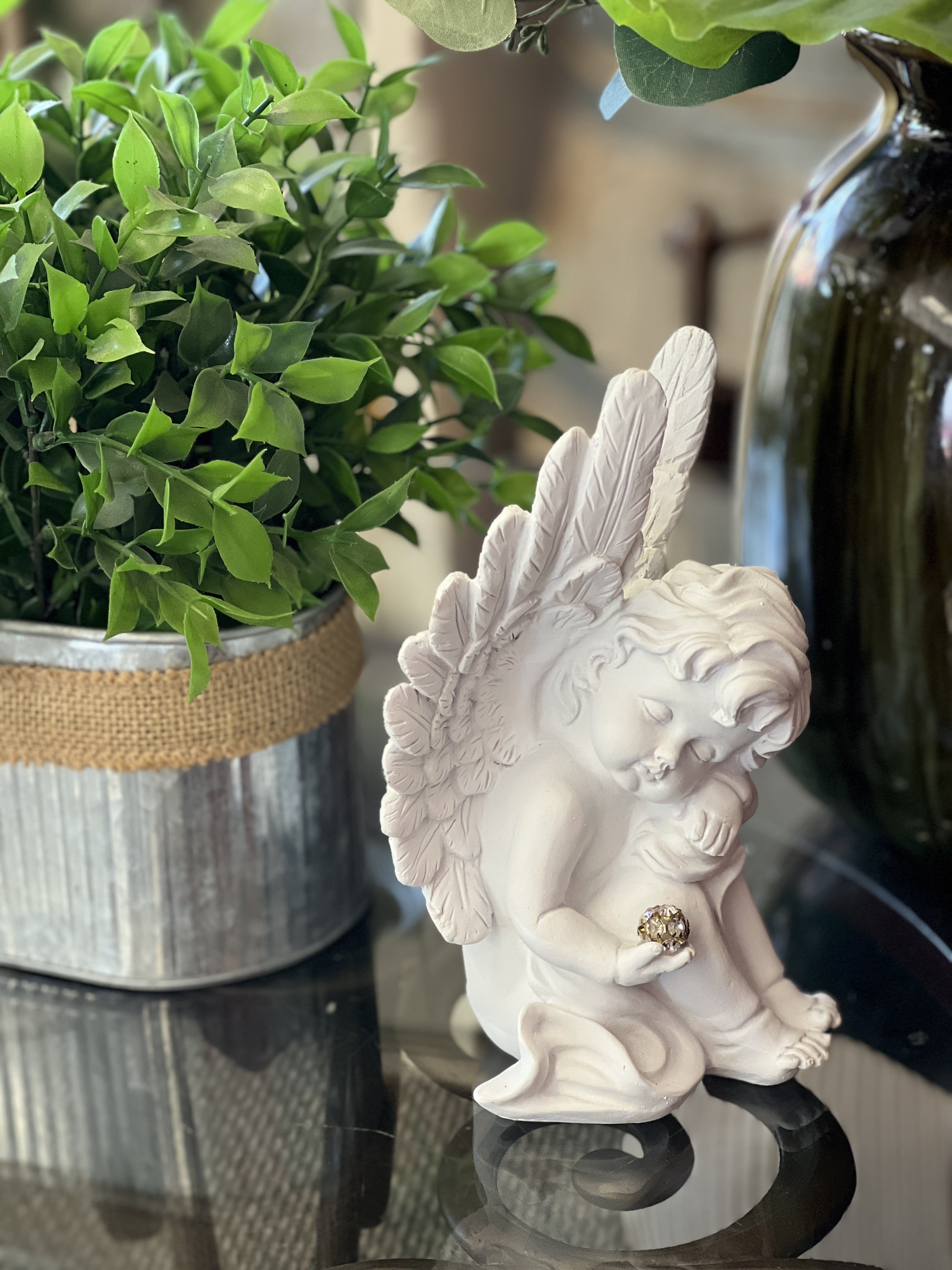 Cherub Cherub - This resin cherub is holding sparkling sphere, with eyes closed and is approx 7.5" tall. Can be added into an arrangement or plant basket if requested in "delivery/special instructions" on check out.