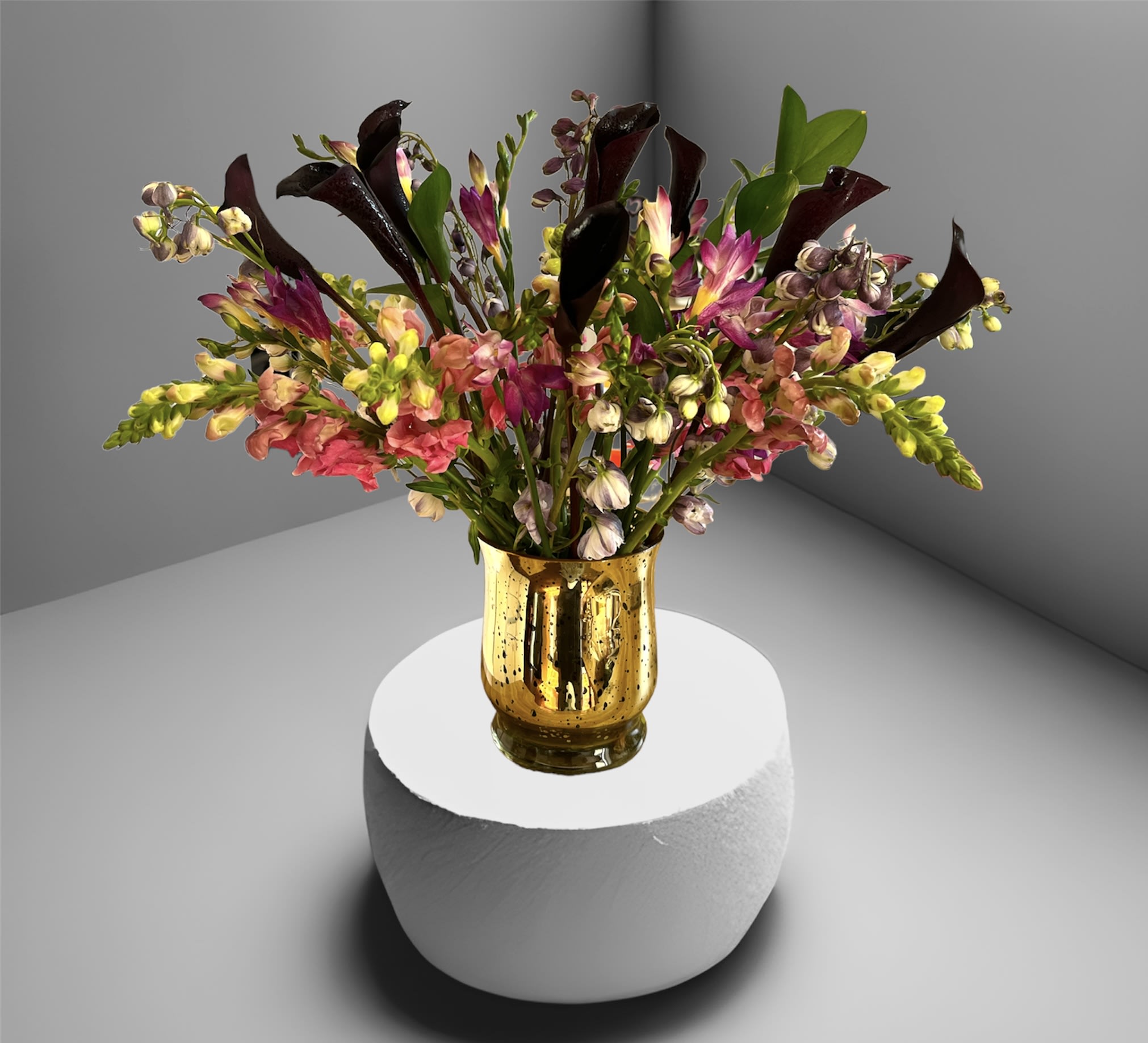 Mystique - A stunning mix of calla lilies, snap dragon, delphinium, freesia and foliage in a mercury glass vase.