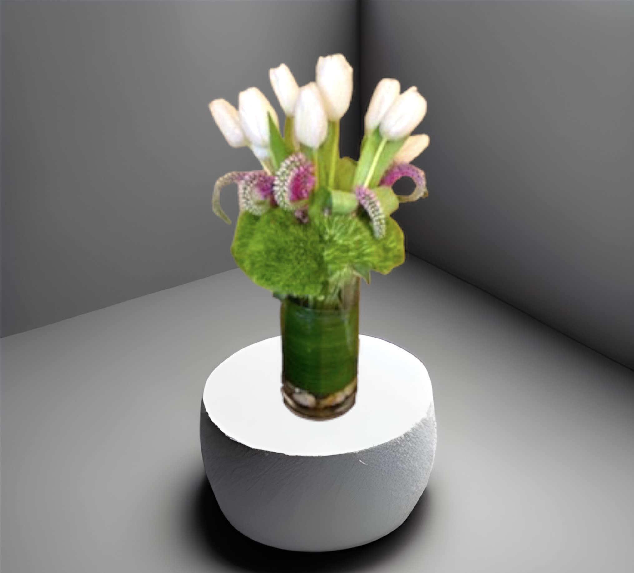 Tulip Spring - An arrangement of tulips in a glass cylinder vase with river rocks and seasonal foliage.   