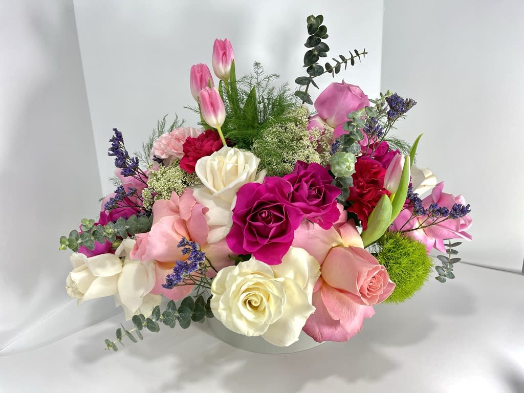 Dearly in Pink - Combination of Roses, Tulips, Carnations, Spray roses, ranunculus, with bright greens to light up the day of your loved one! Dearly in Pink is presented in a light silver box. Perfect for Valentine's Day or any special occasion to show how much you care about them!  Estimated dimensions of arrangement: 12&quot;H x 12&quot;W x 12&quot;D
