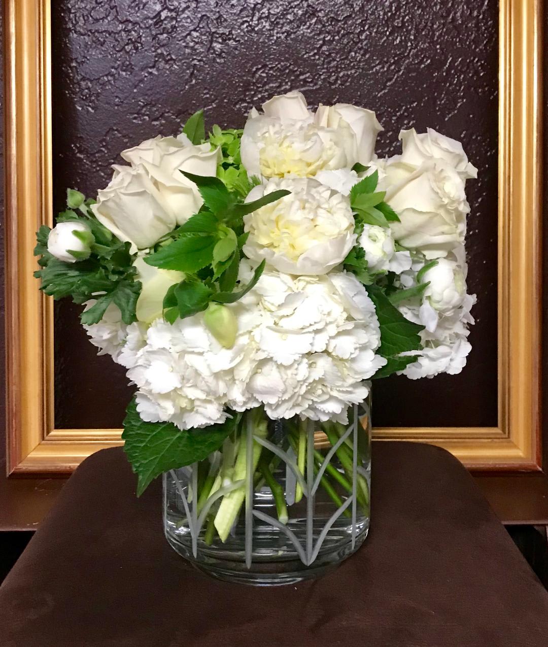 Lush English Garden - White and Green  - A mix of white roses, hydrangea, orchids and other seasonal white flowers in a low vase with touches or dark greens