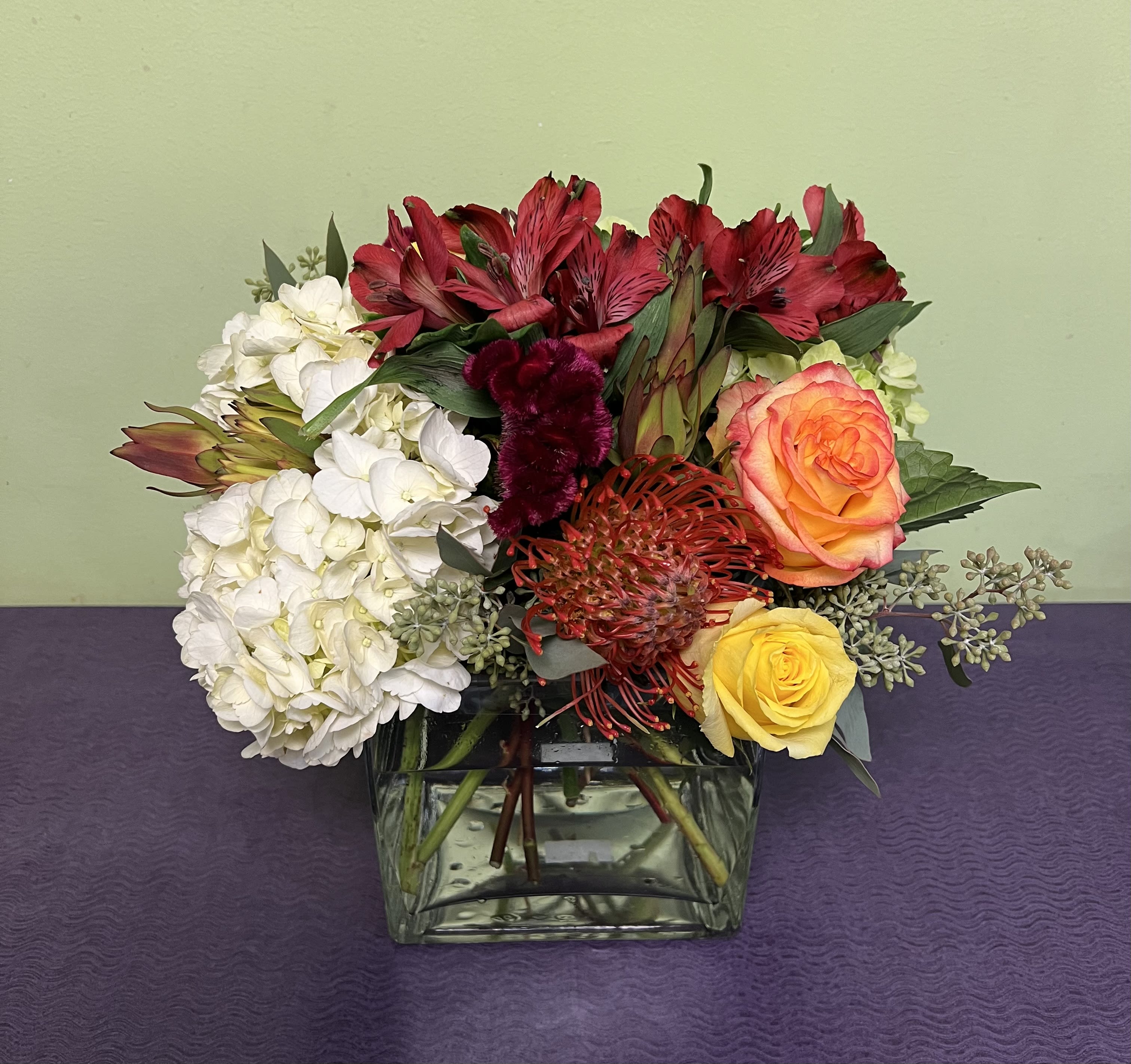 Blazing Blooms - This arrangement is simply on fire with these blazing blooms. What a way to add a bit of brightness to someone's day? This includes Roses, Hydrangeas, Coxcomb, Protea, Alstromeria, Leucadendron, and Eucalyptus.