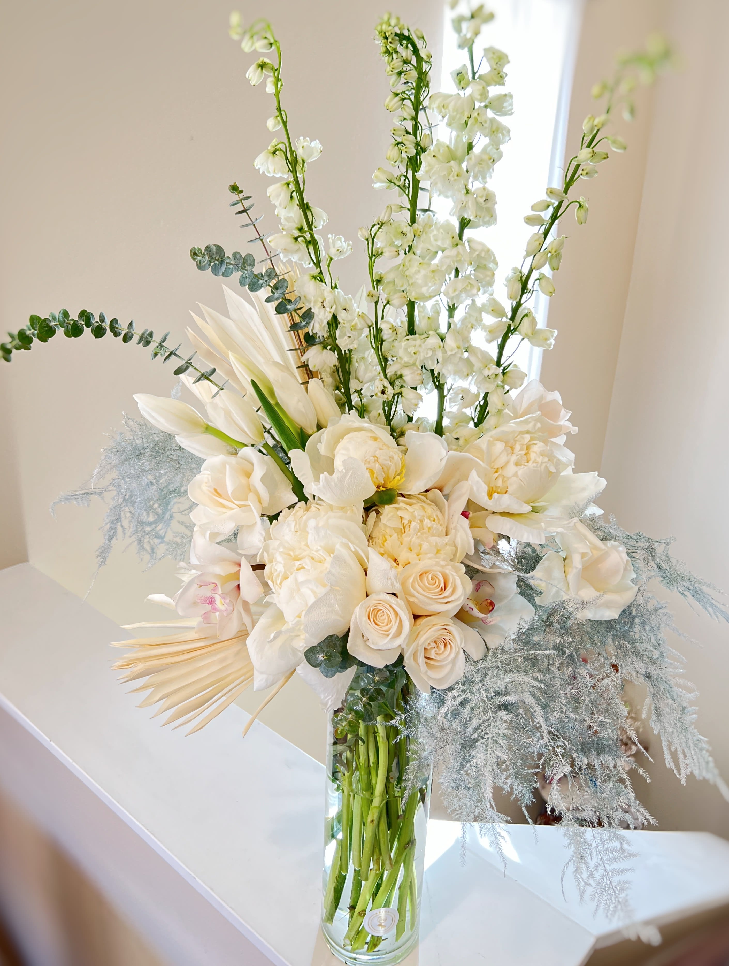 Pure Elegance - Give someone the gift of style – send this tall arrangement of white blush roses ,peonies, white orchids and silver greenery. it’s a graceful display that embodies pure elegance.
