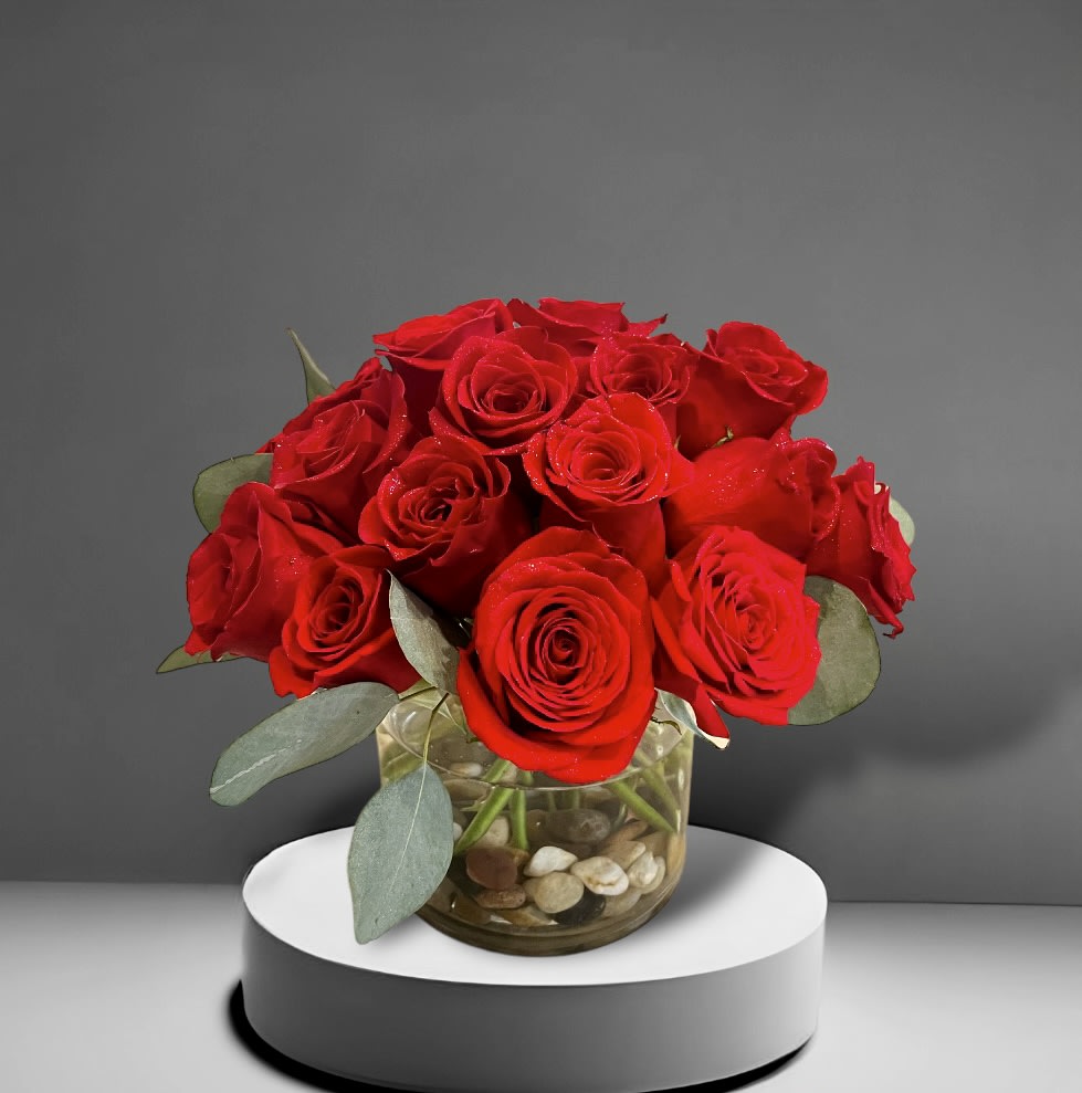 Red Rose Vase - Two dozen red roses in a glass vase with river rocks and foliage.
