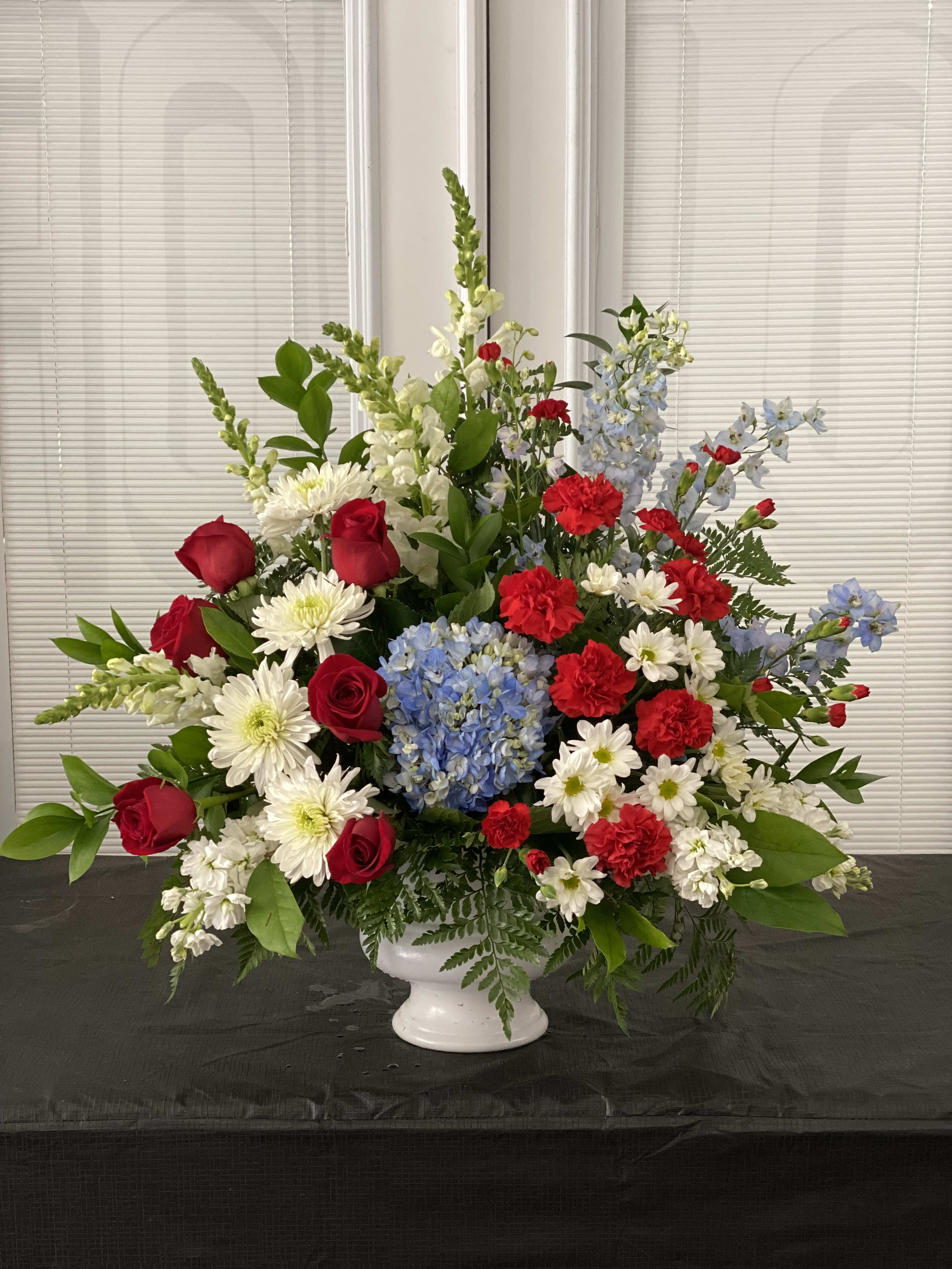 With Distinction - A dazzling display of patriotic red white and blue flowers sends a silent yet poignant statement about hope freedom and the strength to endure. This proud bouquet is a testament to life that is sure to be appreciated.