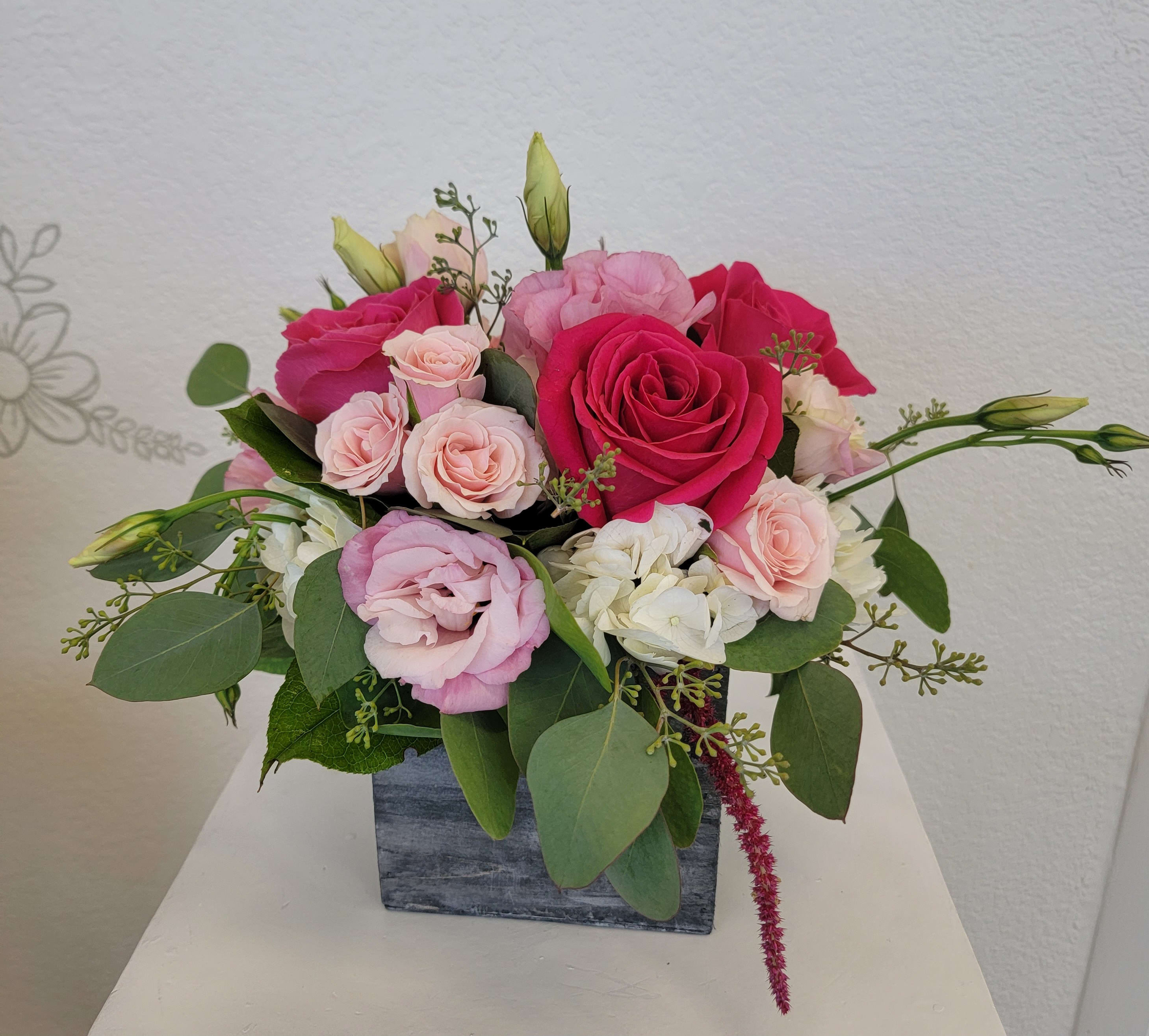 Petite Pink - hot pink roses, light pink lisianthus, hydrangea, spray roses and greenery in a cute wood box. A perfect arrangement for a desk or table.