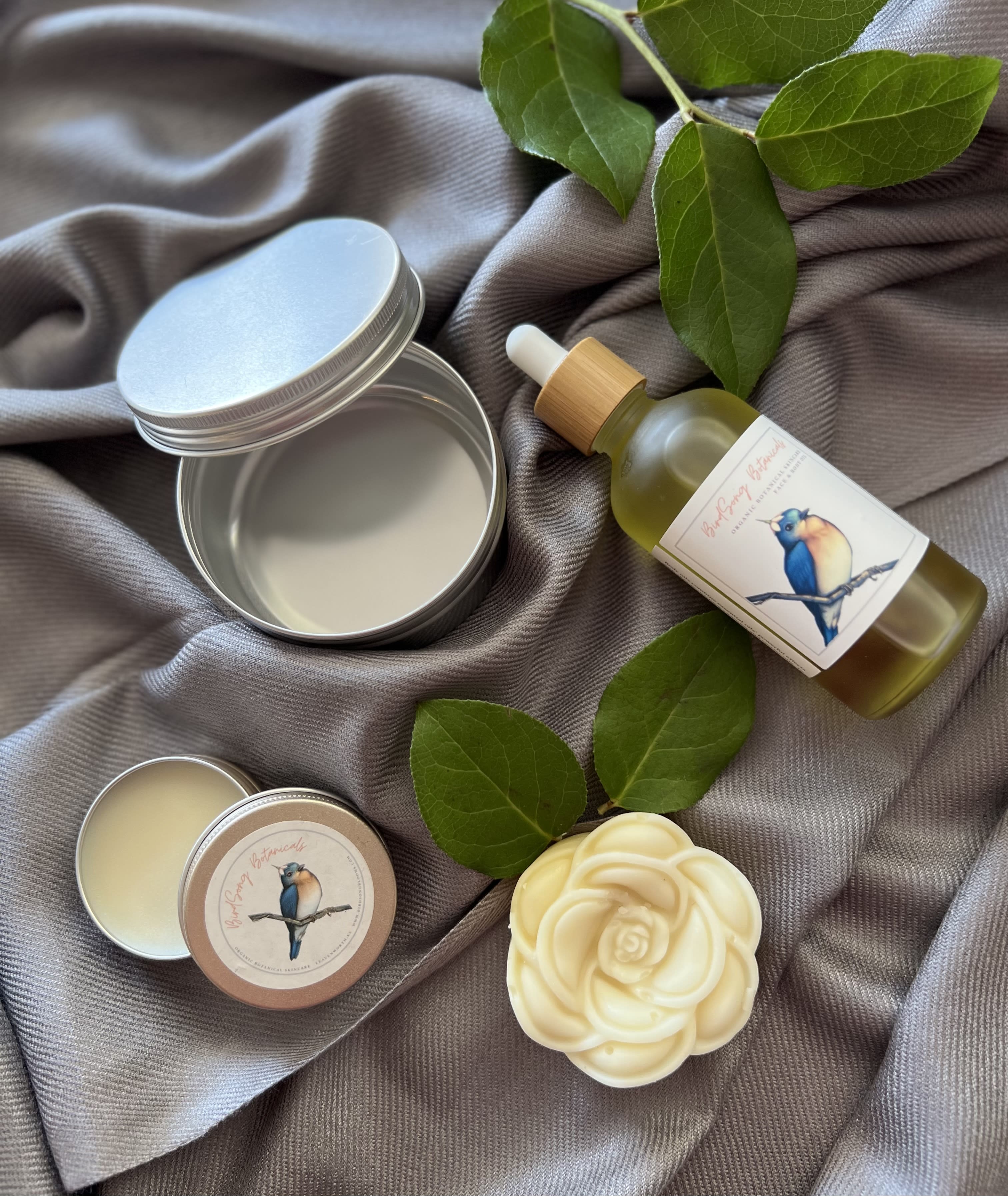 Birdsong Blooms Gift Set - Wild Orchid and White Tea Cuticle and Nail Cream, Floral Infused Face and Body Oil, Heirloom Rose Petal Infused Solid Lotion Body Bar, and Travel Tin expertly gift wrapped for delivery. Made locally in Leavenworth using natural and organic ingredients by BirdSong Blooms.