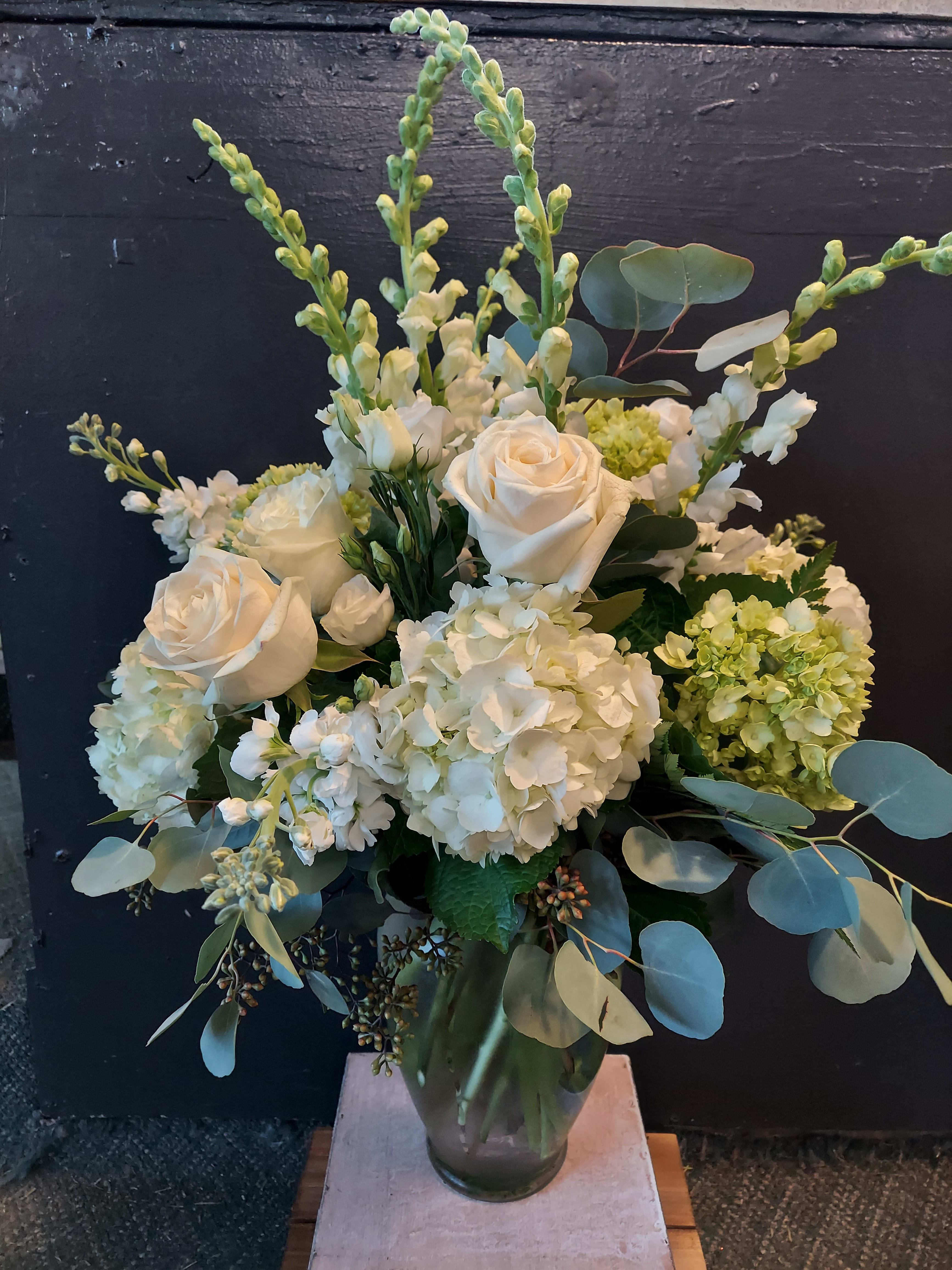 Sky High White Sky High White - Enjoy this beautiful Sunnyside Specialty floral arrangement this holiday season. Mixed greens, soft whites and lots of height!