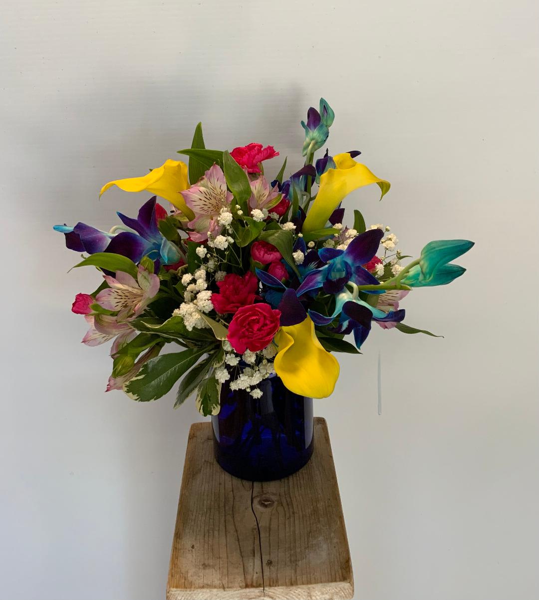 Summer Tropical Standard - Jewel tones play to a tropical Mother's Day this year with this array of orchids and calla lilies.