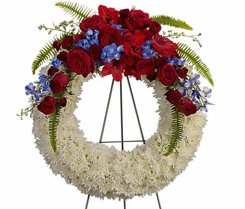 Reflections of Glory Wreath Reflections of Glory Wreath - A stunning display of patriotism strength and sympathy. This red white and blue wreath delivers a lovely message about the dignity of the deceased. A lovely array of flowers such as blue hydrangea red roses and spray roses delicate blue delphinium red gladioli white cushion spray chrysanthemums and more create a circle of serene beauty.
