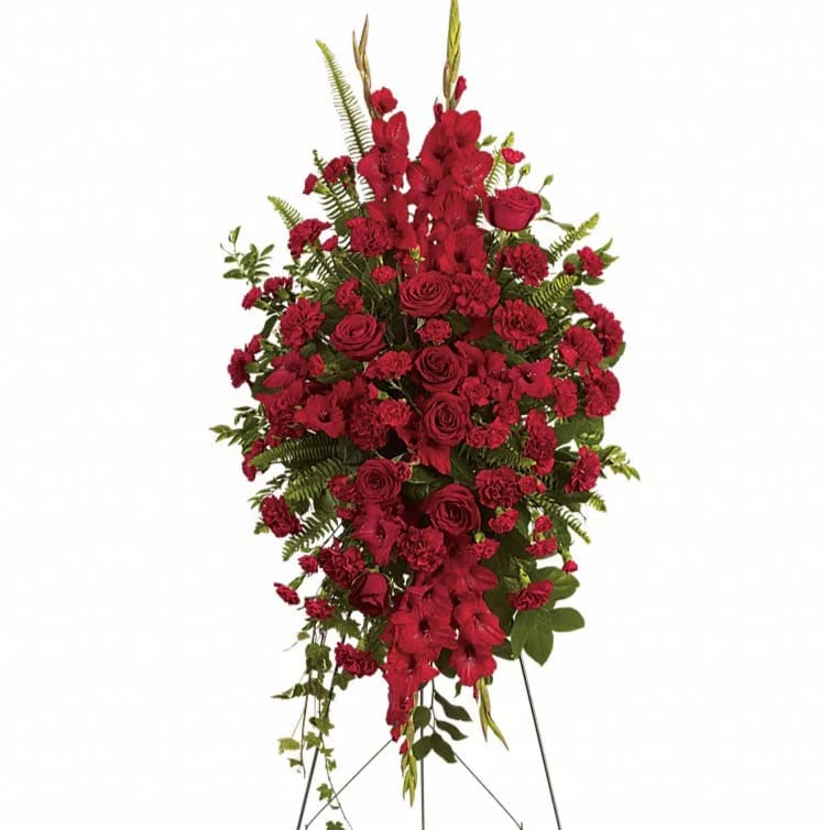 Deep in Our Hearts Spray - This rich radiant spray of red roses gladioli and other popular red flowers during a time of loss conveys a message of reassurance and hope in a difficult time. The radiant arrangement includes red roses red gladioli red carnations and red miniature carnations accented with assorted greenery.