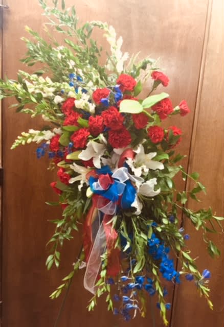 Patriotic-standing-spray - White-snapdragons,-red-carnations,-white-lilies-and-blue-delphinum